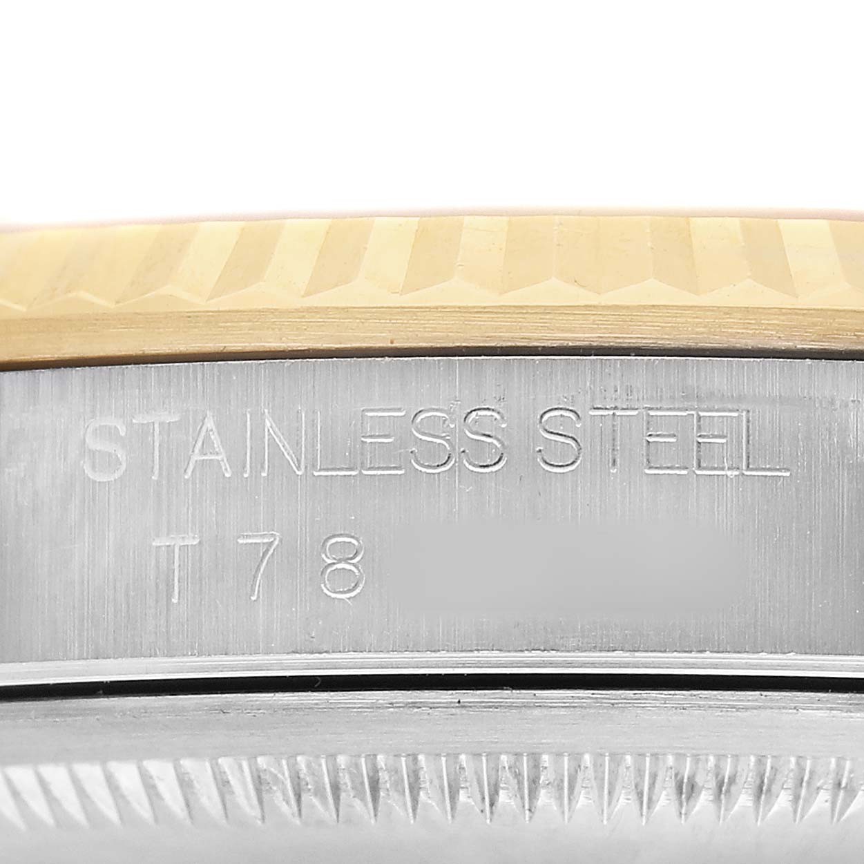 The image shows the side engraving on the stainless steel case and the edge of the fluted bezel of a Rolex Datejust 81443 Men's Steel and Gold (two tone) Champagne Dial.