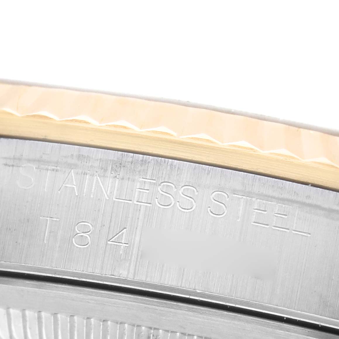 The image shows a close-up of the side and rim of a Rolex Datejust 16233 Men's Steel and Gold (two tone) Champagne Dial, highlighting the stainless steel section with engraved text.