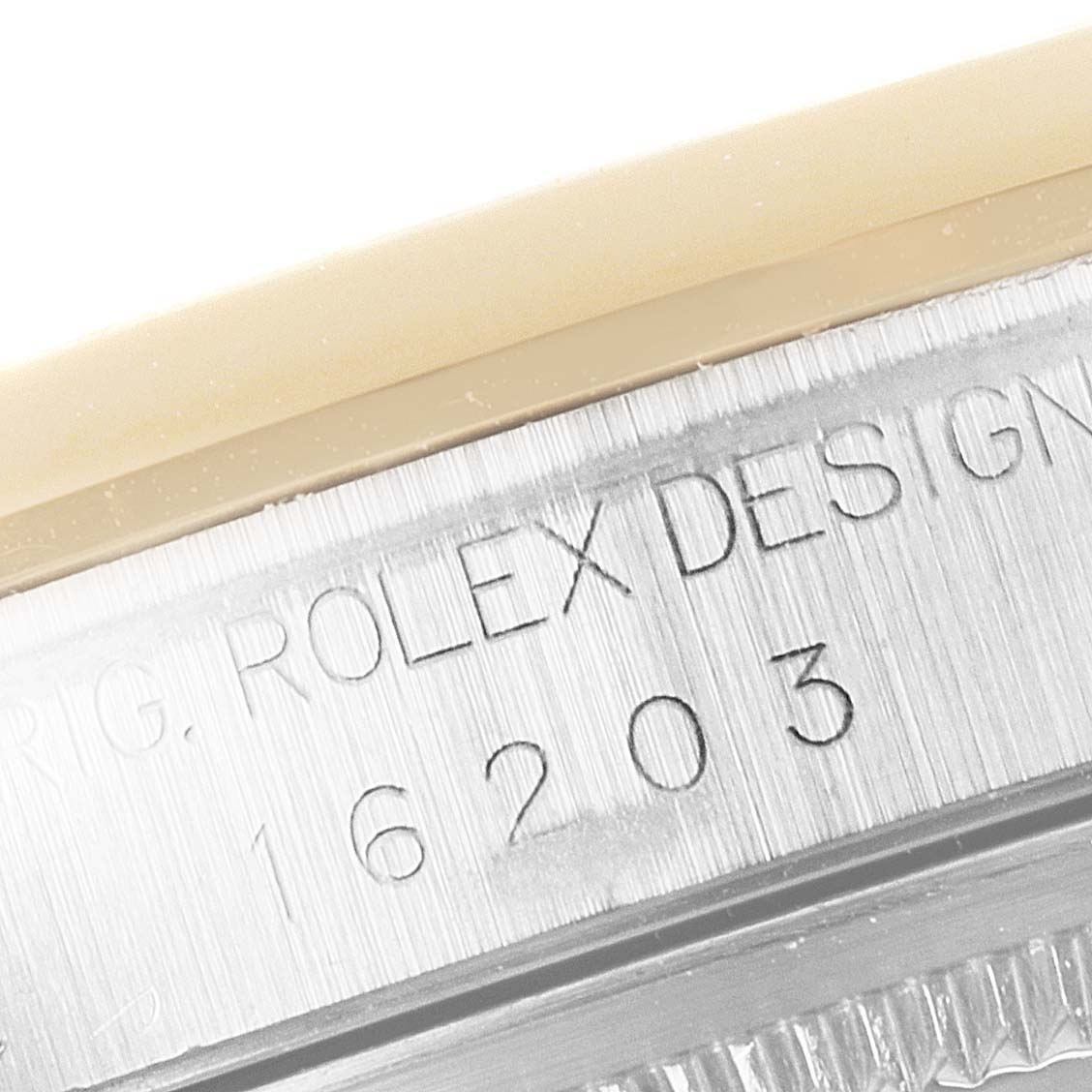 The image shows a close-up angle of the engraved serial number and bezel of a Rolex Datejust 16203 Men's Steel and Gold (two tone) White Dial 16203 Men's Steel and Gold (two tone) White Dial watch.