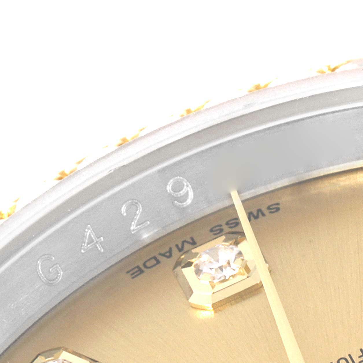 The image shows a close-up of the serial number engraving and part of the dial of a Rolex Datejust 116243 Men's Steel and Gold (two tone) Champagne Dial 116243 Men's Steel and Gold (two tone) Champagne Dial watch.