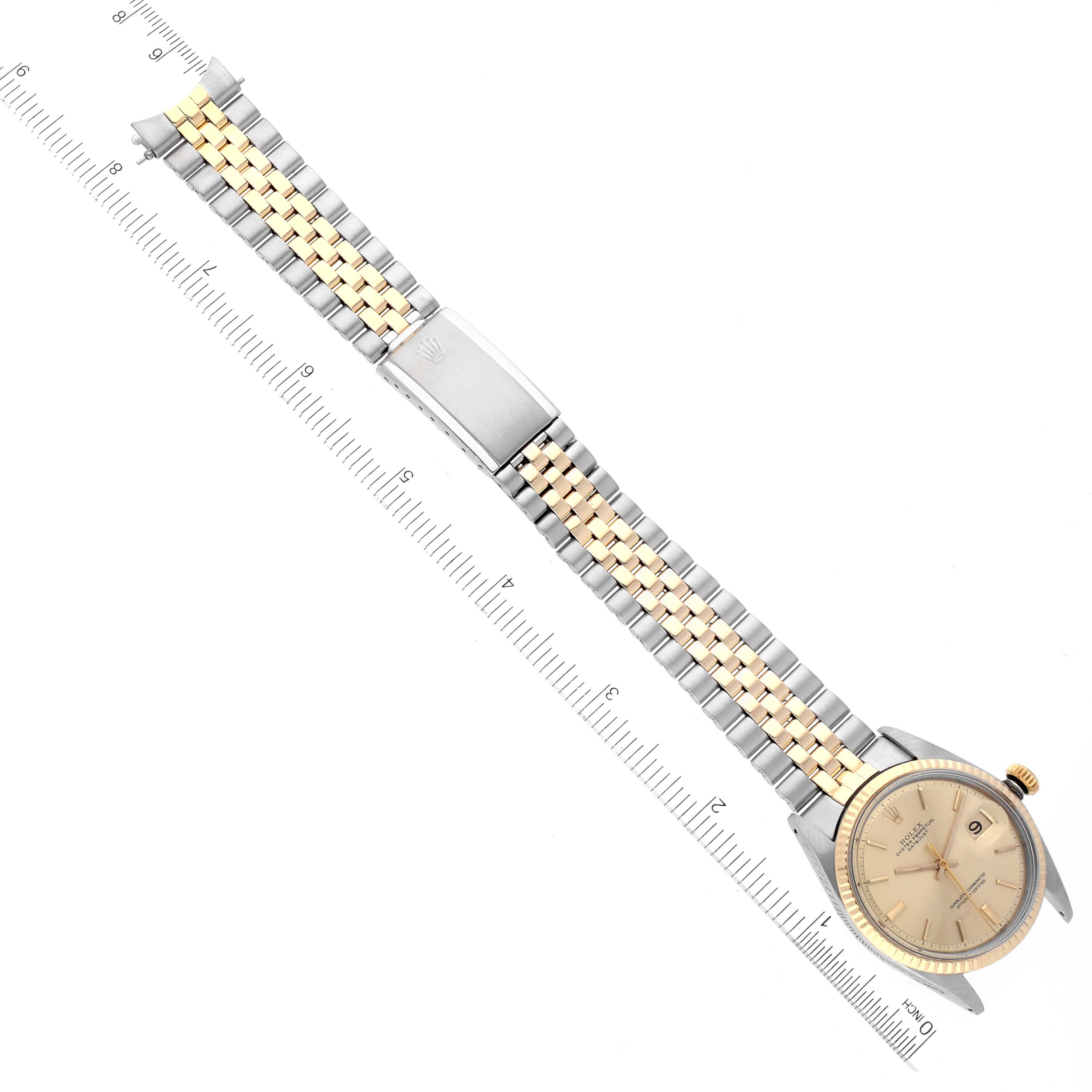 The Rolex Vintage Collection 1601 Men
s Steel and Gold (two tone) Champagne Dial 1601 Men
s Steel and Gold (two tone) Champagne Dial watch is shown from an overhead view, displaying the face, bezel, bracelet, and clasp alongside a ruler.