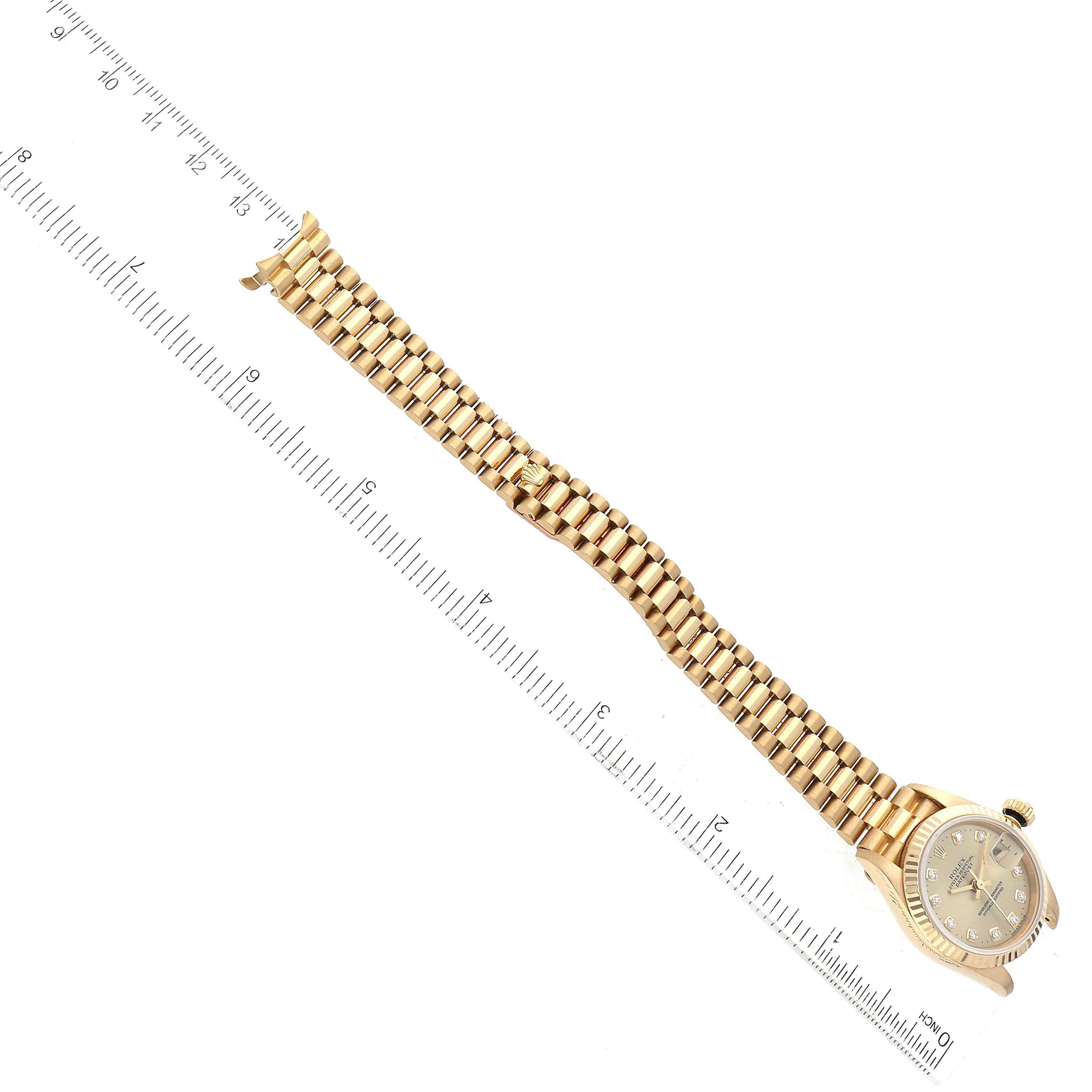 The image shows a Rolex President 69178 Women's Yellow Gold Champagne Dial 69178 Women's Yellow Gold Champagne Dial model watch from an overhead angle, showcasing its bracelet, dial, and a ruler for scale.