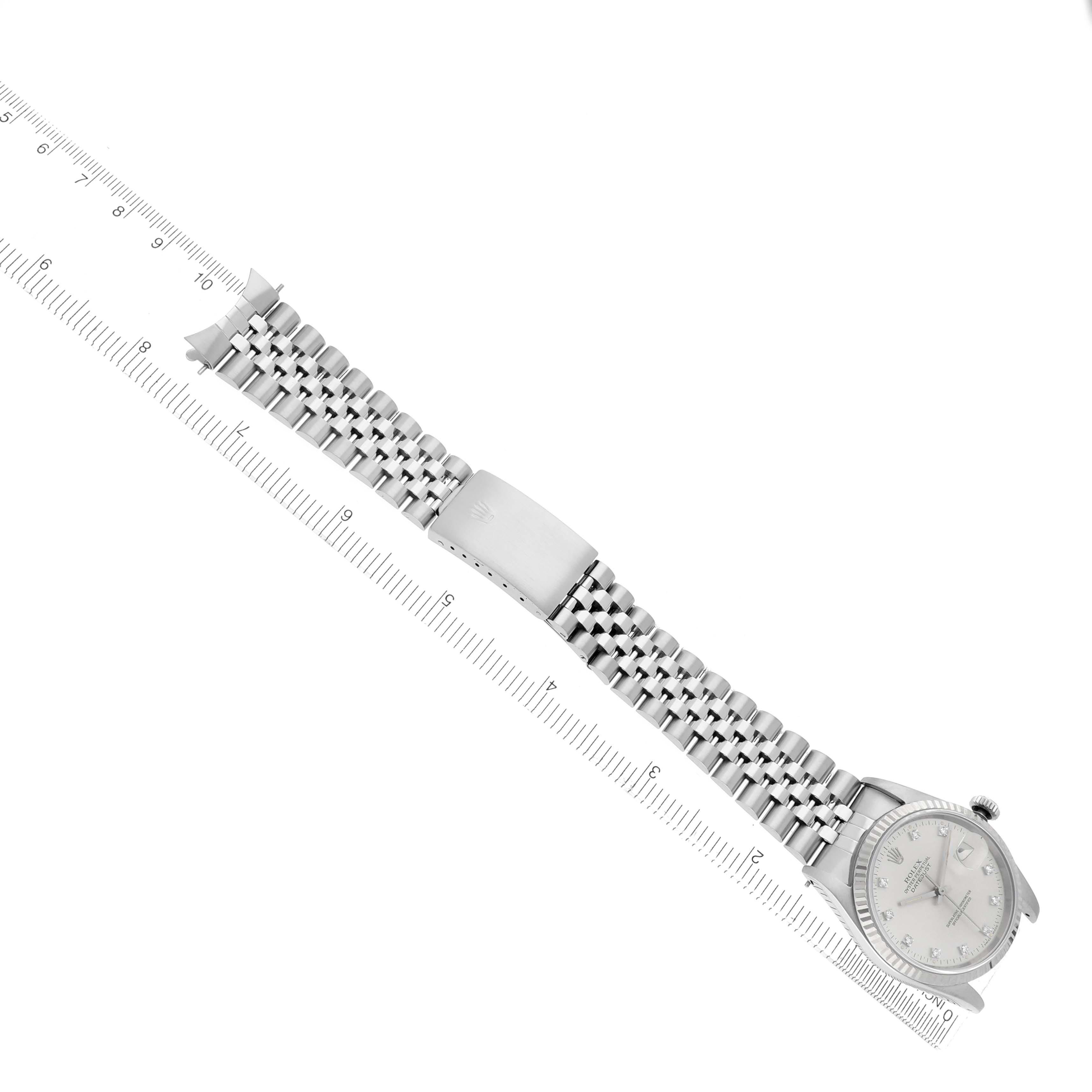 The image shows a Rolex Datejust 16220 Men
s Stainless Steel Silver Dial 16220 Men
s Stainless Steel Silver Dial watch angled diagonally with its band extended next to a ruler.