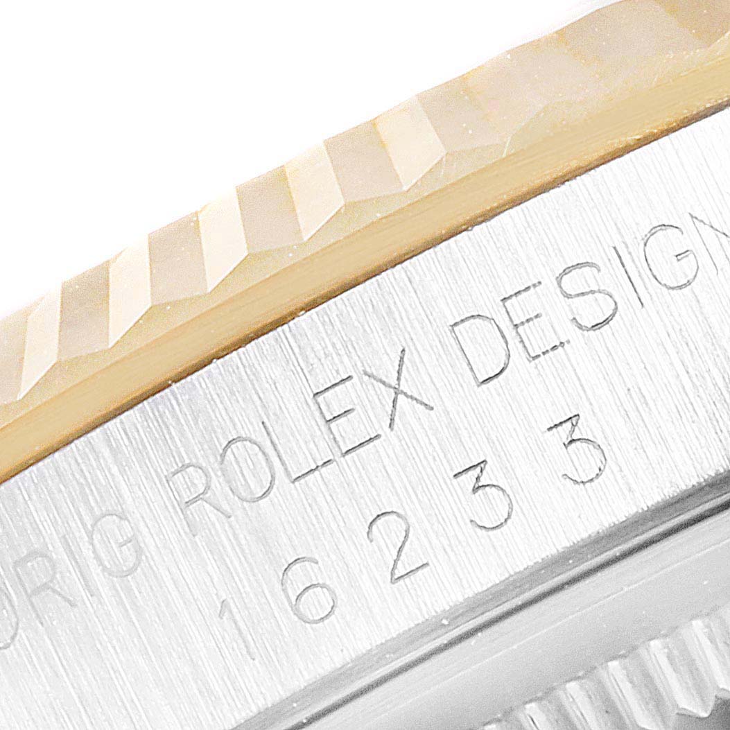 This close-up image shows the engraved side of the bezel and case of a Rolex Datejust 16233 Men's Steel and Gold (two tone) Beige Dial 16233 Men's Steel and Gold (two tone) Beige Dial watch.