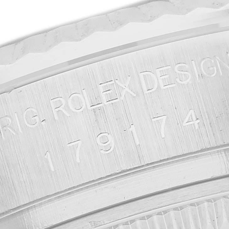 The image shows a close-up of the side of a Rolex Datejust 179174 Women
s Stainless Steel Mother of Pearl Dial 179174 Women
s Stainless Steel Mother of Pearl Dial watch, highlighting engraved text on the case.