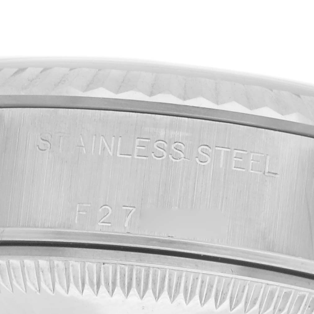 The image shows a close-up of the stainless steel side of a Rolex Datejust 79174 Women
s Stainless Steel White Dial 79174 Women
s Stainless Steel White Dial watch with part of the fluted bezel visible.