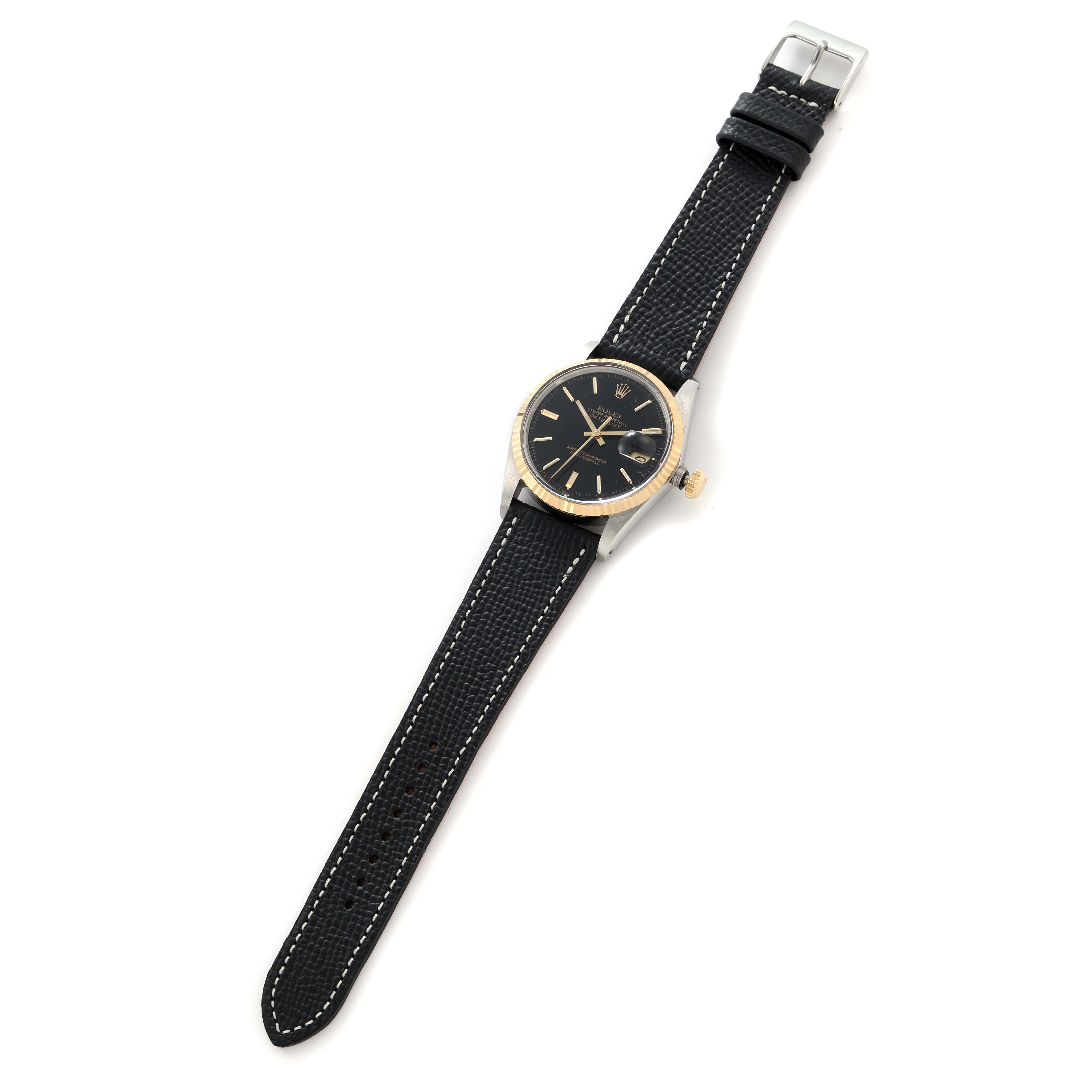 The Rolex Datejust 16013 Men
s Steel and Gold (two tone) Black Dial 16013 Men
s Steel and Gold (two tone) Black Dial watch is shown from a top-down angle, displaying the full face, bezel, and strap.