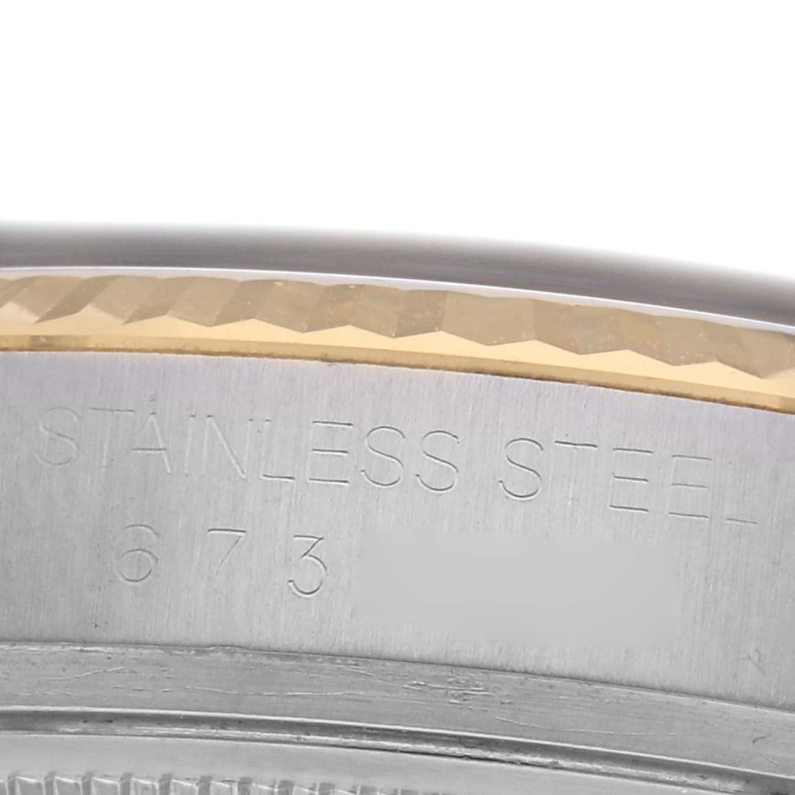 The image shows a close-up of the edge of a Rolex Datejust 16013 Men
s Steel and Gold (two tone) Black Dial 16013 Men
s Steel and Gold (two tone) Black Dial watch, highlighting the stainless steel texture and engraved details.