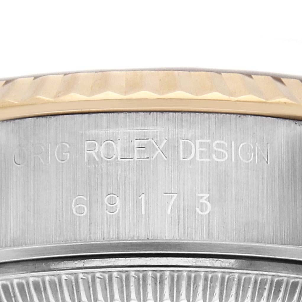 The image shows a close-up of the Rolex Datejust 69173 Women's Steel and Gold (two tone) Black Dial 69173 Women's Steel and Gold (two tone) Black Dial's case side, highlighting the bezel and engraved design.