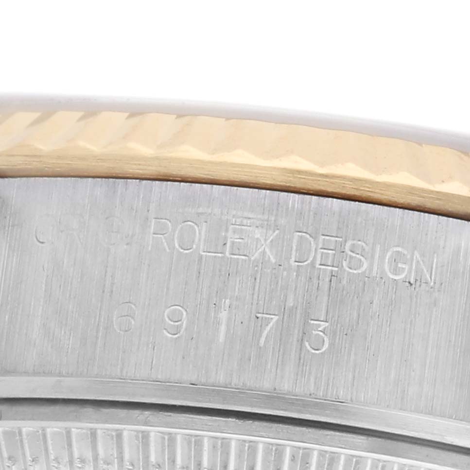 The image shows the side view of the Rolex Datejust 69173 Women
s Steel and Gold (two tone) White Dial 69173 Women
s Steel and Gold (two tone) White Dial
s case, highlighting the bezel and engraved model number.