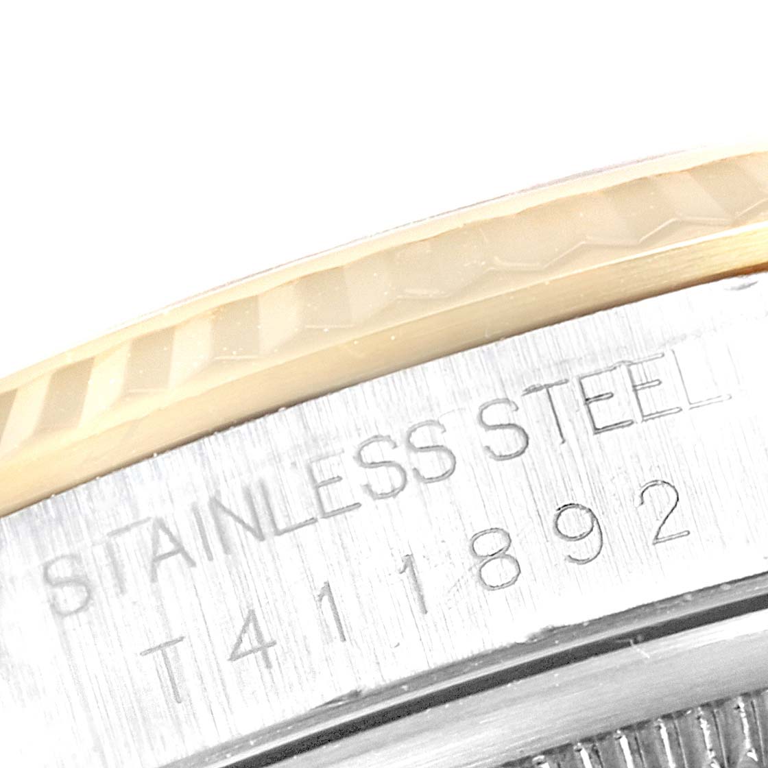 This image shows a close-up of the side of the Rolex Datejust 16233 Men
s Stainless Steel White Dial 16233 Men
s Stainless Steel White Dial watch, focusing on the engraved serial number and "STAINLESS STEEL" text.