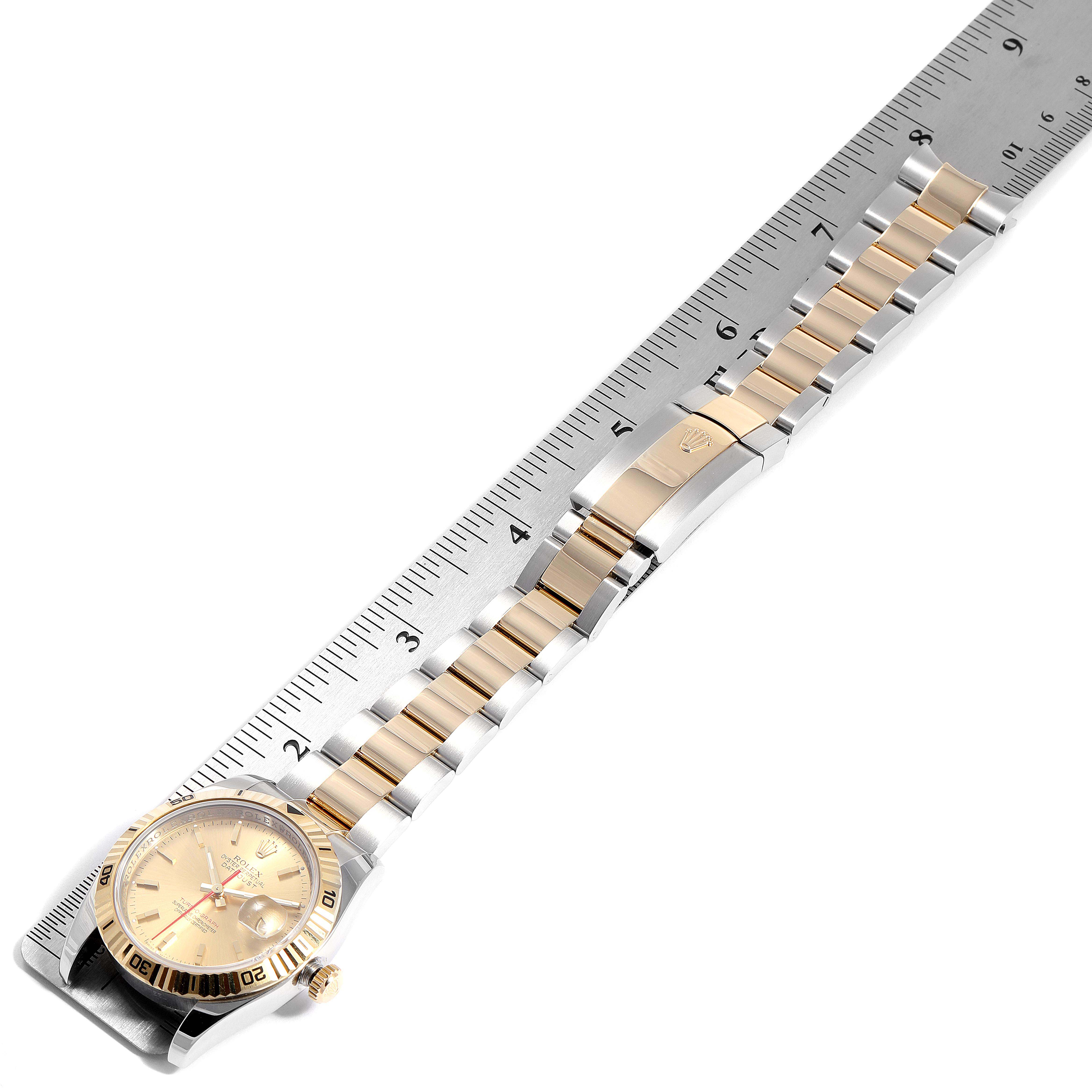 The image shows the Rolex Turn-o-Graph 116263 Men
s Steel and Gold (two tone) Champagne Dial 116263 Men
s Steel and Gold (two tone) Champagne Dial watch laid flat with the face and band visible, aligned with a ruler for measurement.