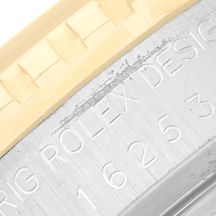 This close-up view of the Rolex Turn-o-Graph 16253 Men
s Steel and Gold (two tone) Silver Dial 16253 Men
s Steel and Gold (two tone) Silver Dial watch shows part of the fluted bezel and case with engraved text.