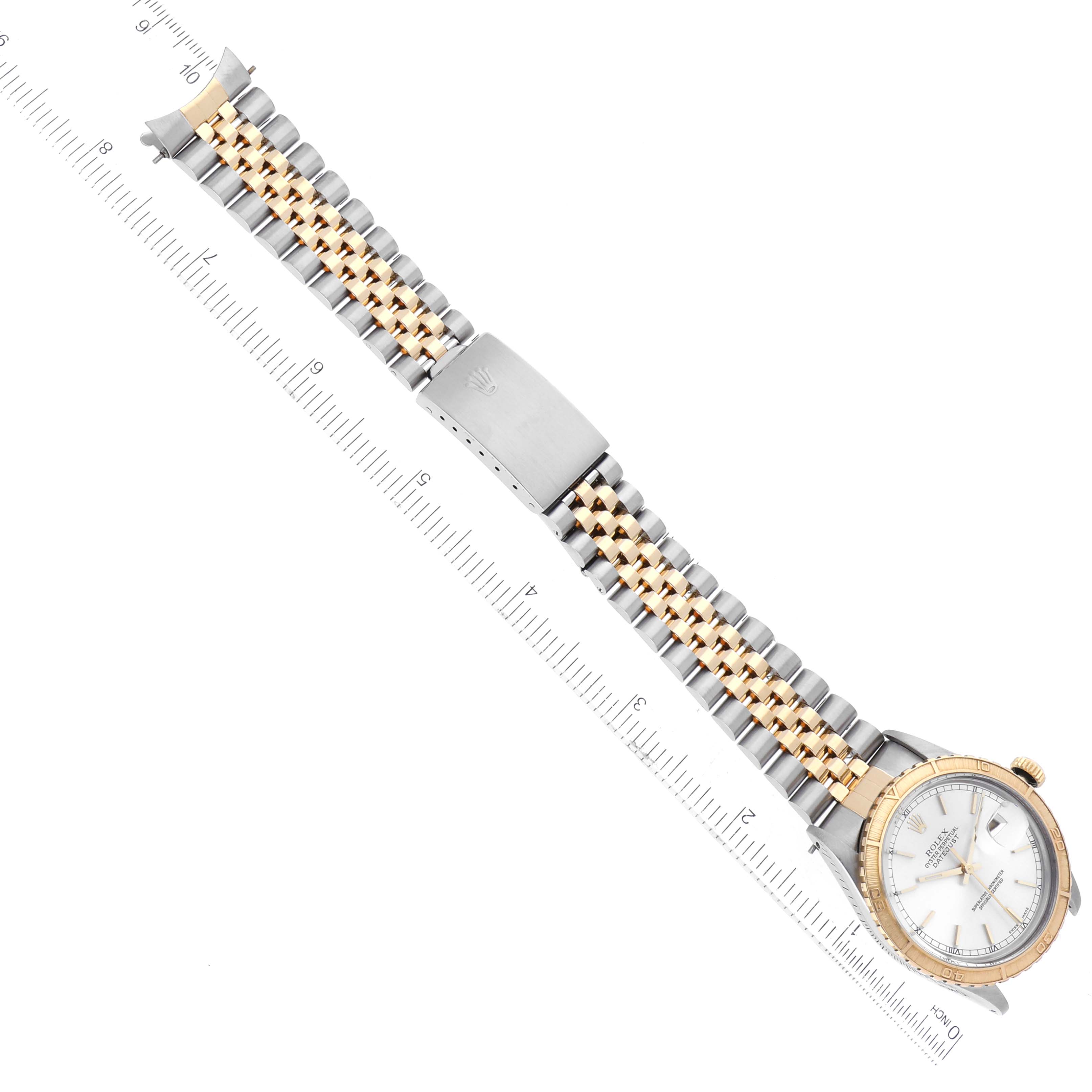 The image shows a Rolex Turn-o-Graph 16253 Men
s Steel and Gold (two tone) Silver Dial 16253 Men
s Steel and Gold (two tone) Silver Dial watch laid flat, featuring a gold and silver bracelet alongside a ruler for scale.