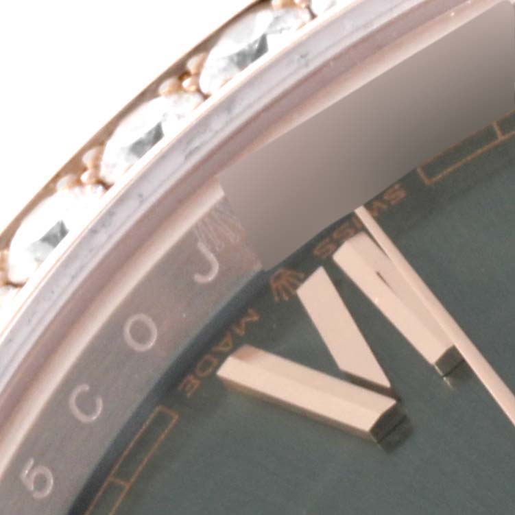 This close-up image of a Rolex President 228345 Men's Rose Gold Green Dial 228345 Men's Rose Gold Green Dial model watch shows the bezel decorated with diamonds and part of the dial with hour markers.