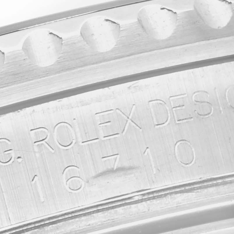 The image shows a close-up of the Rolex GMT-Master 16710 Men
s Stainless Steel Black Dial 16710 Men
s Stainless Steel Black Dial bezel edge and engraved case details.