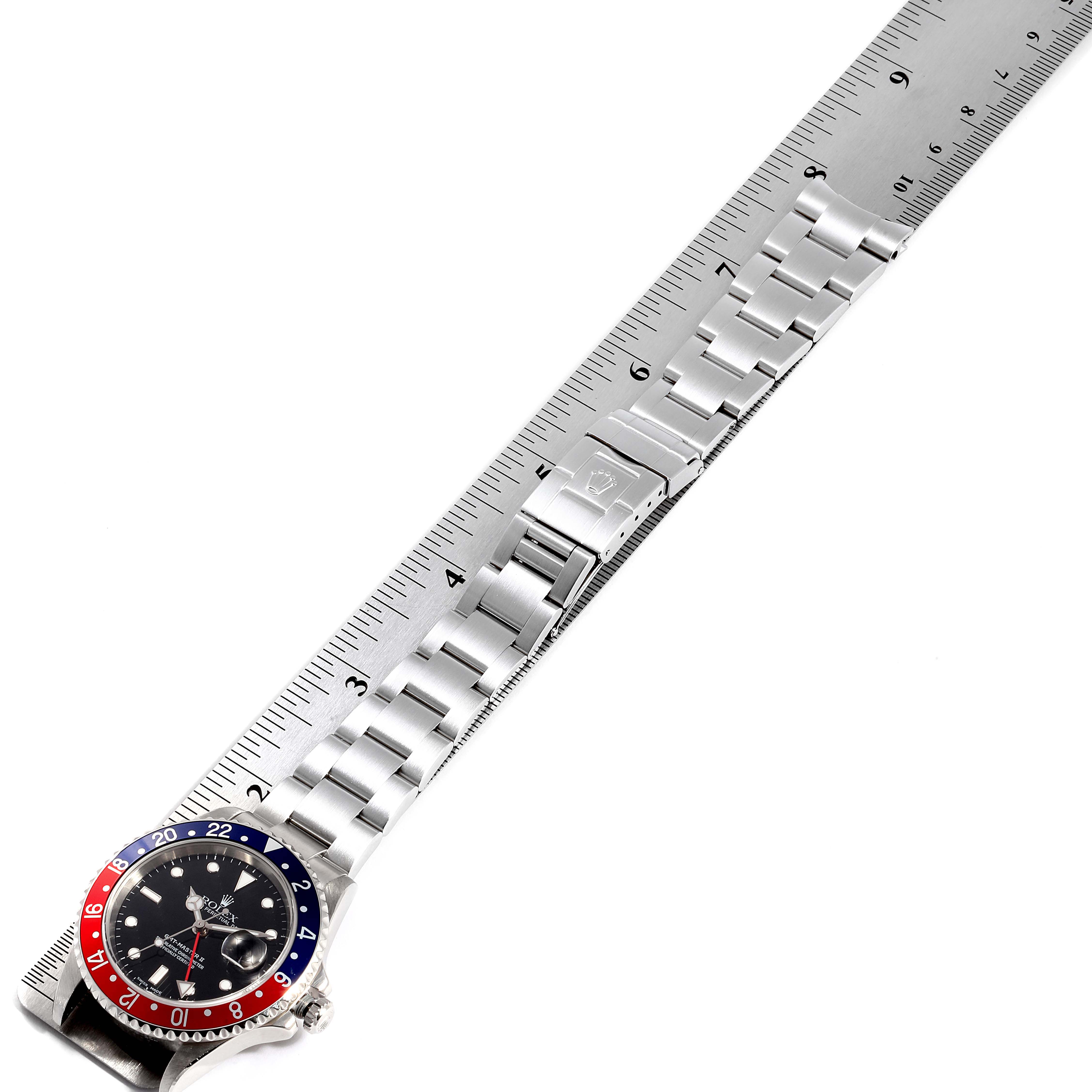 The image shows a Rolex GMT-Master 16710 Men's Stainless Steel Black Dial 16710 Men's Stainless Steel Black Dial watch laying flat with its bezel, dial, and stainless steel bracelet visible, measured against a ruler. 