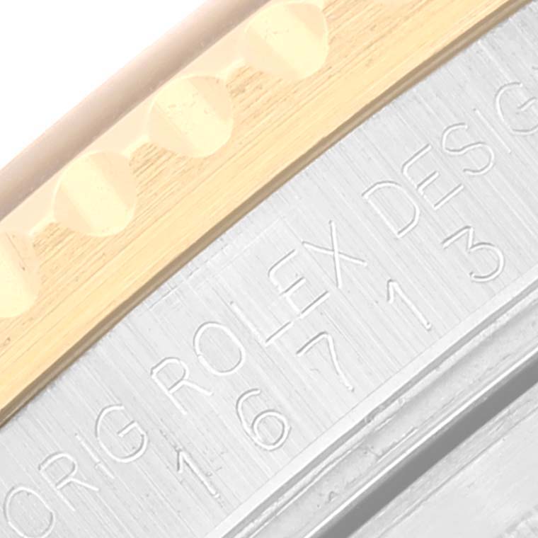 The image shows a close-up of the case side of a Rolex GMT-Master 16713 Men's Steel and Gold (two tone) Brown Dial 16713 Men's Steel and Gold (two tone) Brown Dial watch, highlighting the engraved model number and part of the bezel.