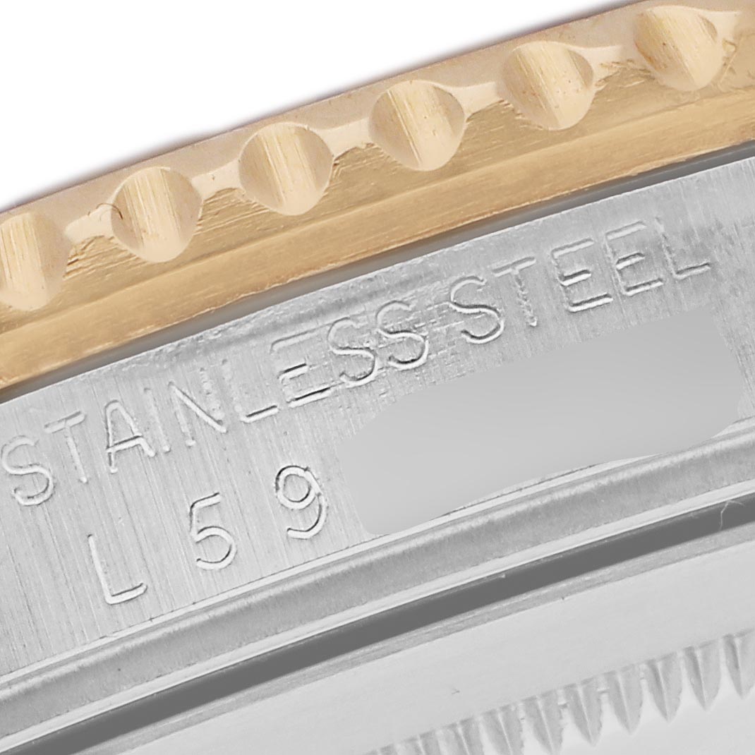 The image shows a close-up of the Rolex GMT-Master 16713 Men's Steel and Gold (two tone) Brown Dial 16713 Men's Steel and Gold (two tone) Brown Dial's stainless steel case and bezel edge.