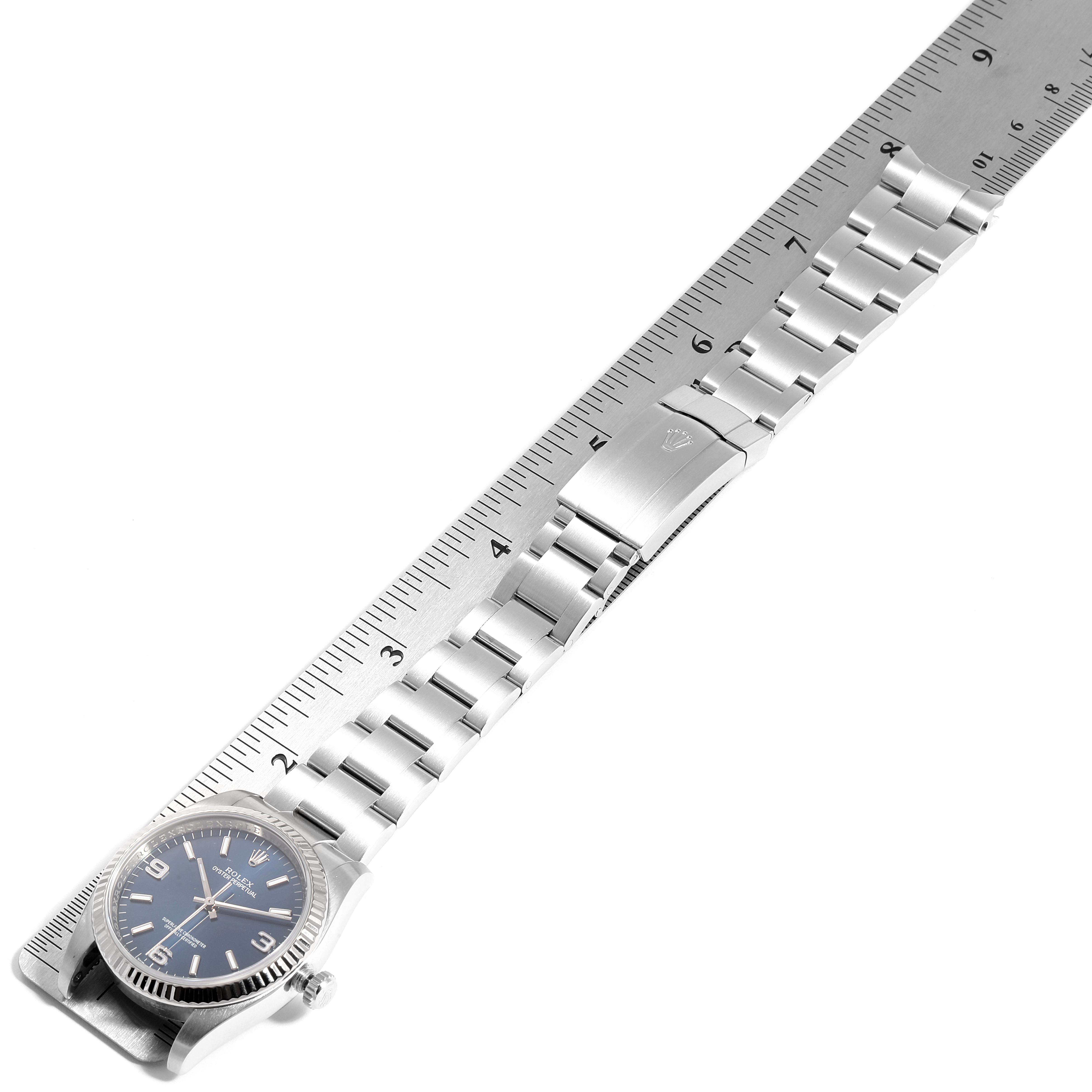 The image shows a Rolex Oyster Perpetual 116034 Men's Stainless Steel Blue Dial 116034 Men's Stainless Steel Blue Dial watch laid flat with its bracelet and clasp extended alongside a ruler for measurement.