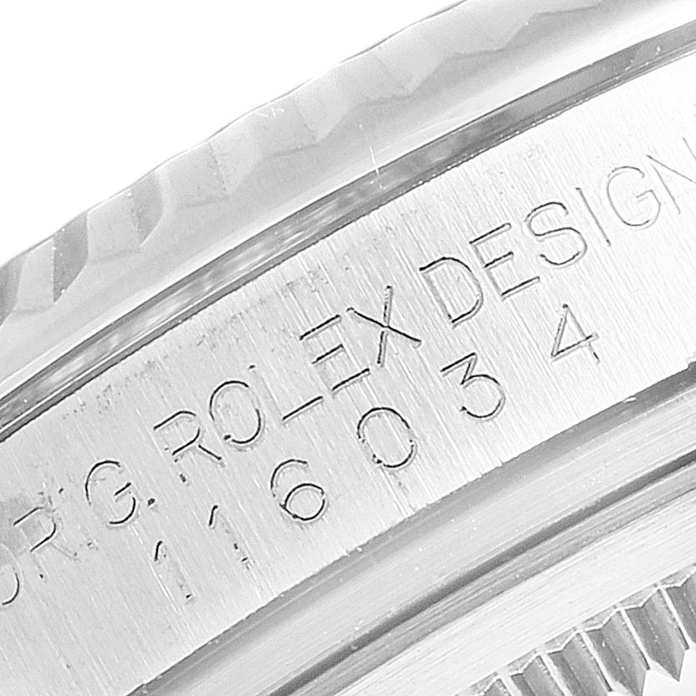 The image shows a close-up angle of the engraved side of the Rolex Oyster Perpetual 116034 Men's Stainless Steel Blue Dial 116034 Men's Stainless Steel Blue Dial watch case.