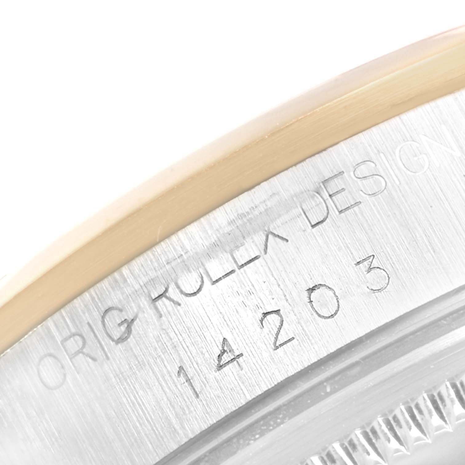 This close-up image of the Rolex Oyster Perpetual 14203 Men's Steel and Gold (two tone) Grey Dial 14203 Men's Steel and Gold (two tone) Grey Dial watch shows the engraved serial number and "ROLEX DESIGN" text on the case.