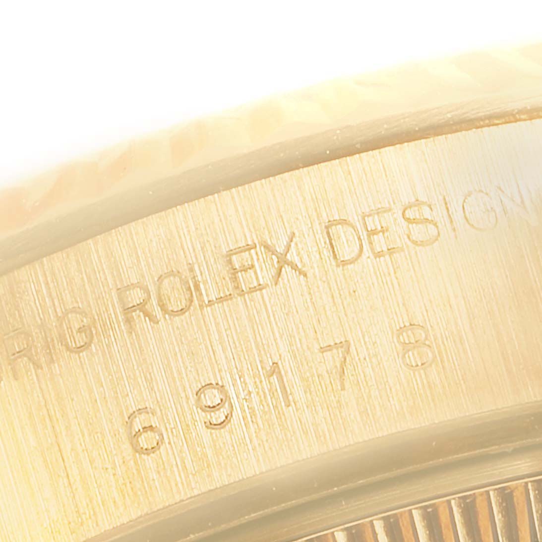 The image shows a close-up of the side of a Rolex President 69178 Women's Yellow Gold Black Dial 69178 Women's Yellow Gold Black Dial model, focusing on the engraved text and part of the bezel.