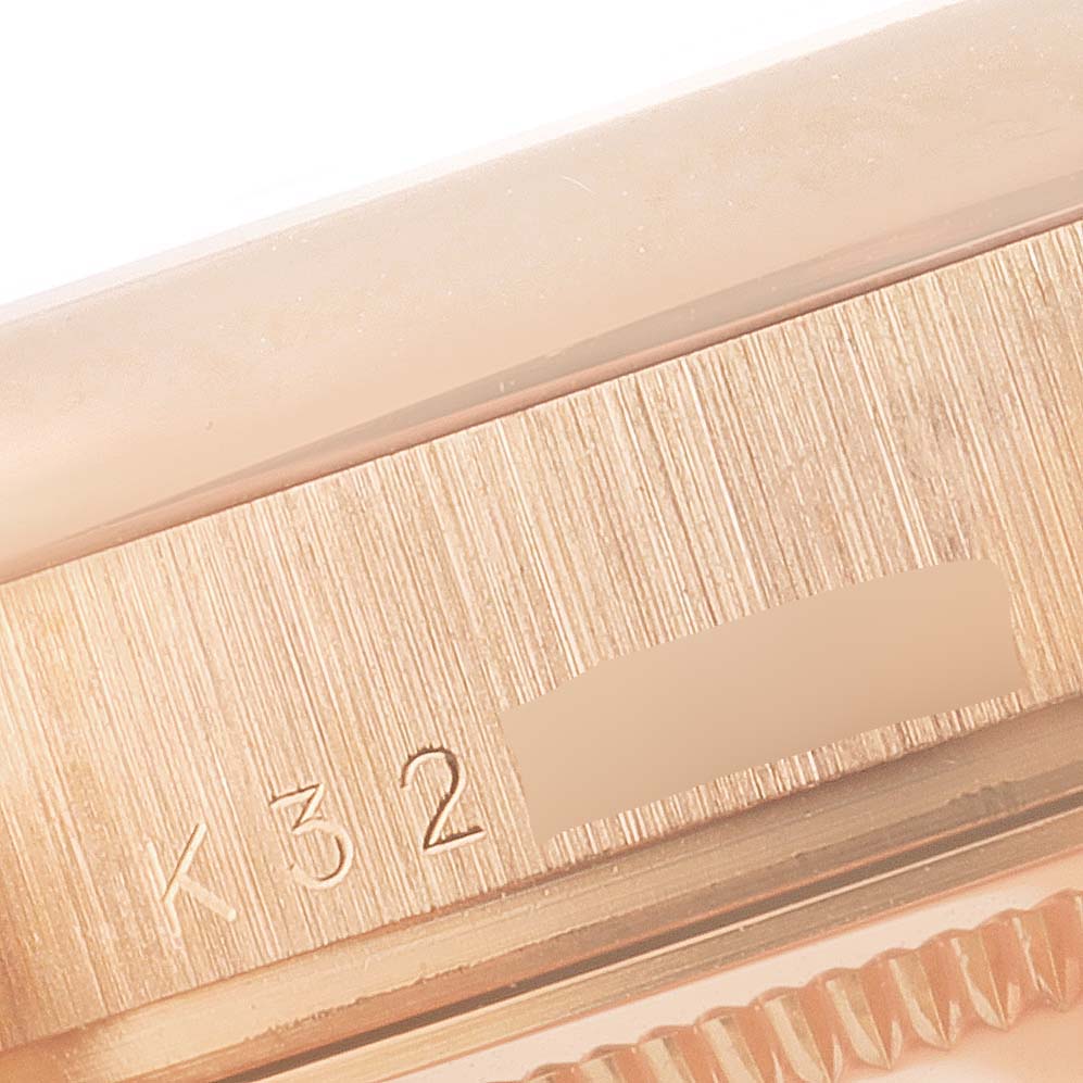This close-up image shows part of the casing and serial number engraving of a Rolex President 118205 Men's Rose Gold Silver Dial 118205 Men's Rose Gold Silver Dial model watch.