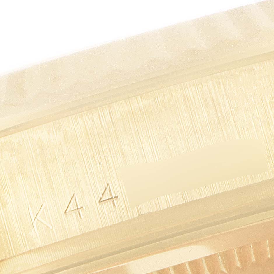 This close-up image shows the side of the bezel and part of the case with engravings on a Rolex President 118238 Men
s Yellow Gold Black Dial 118238 Men
s Yellow Gold Black Dial model watch.