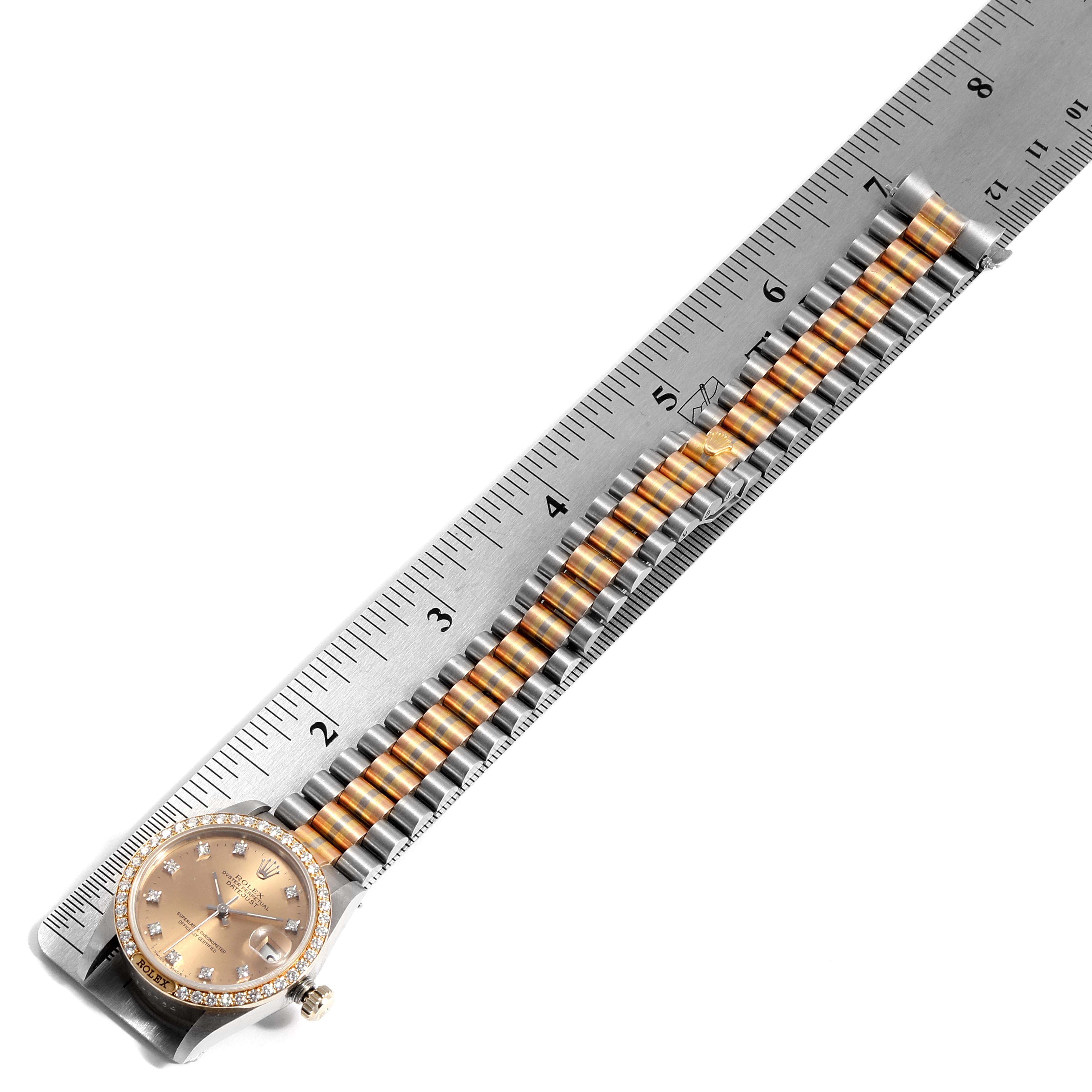 The Rolex President 68149 Women's Yellow Gold Brown Dial 68149 Women's Yellow Gold Brown Dial model watch is shown from a top-down angle with a focus on the dial and entire bracelet laid alongside a ruler.