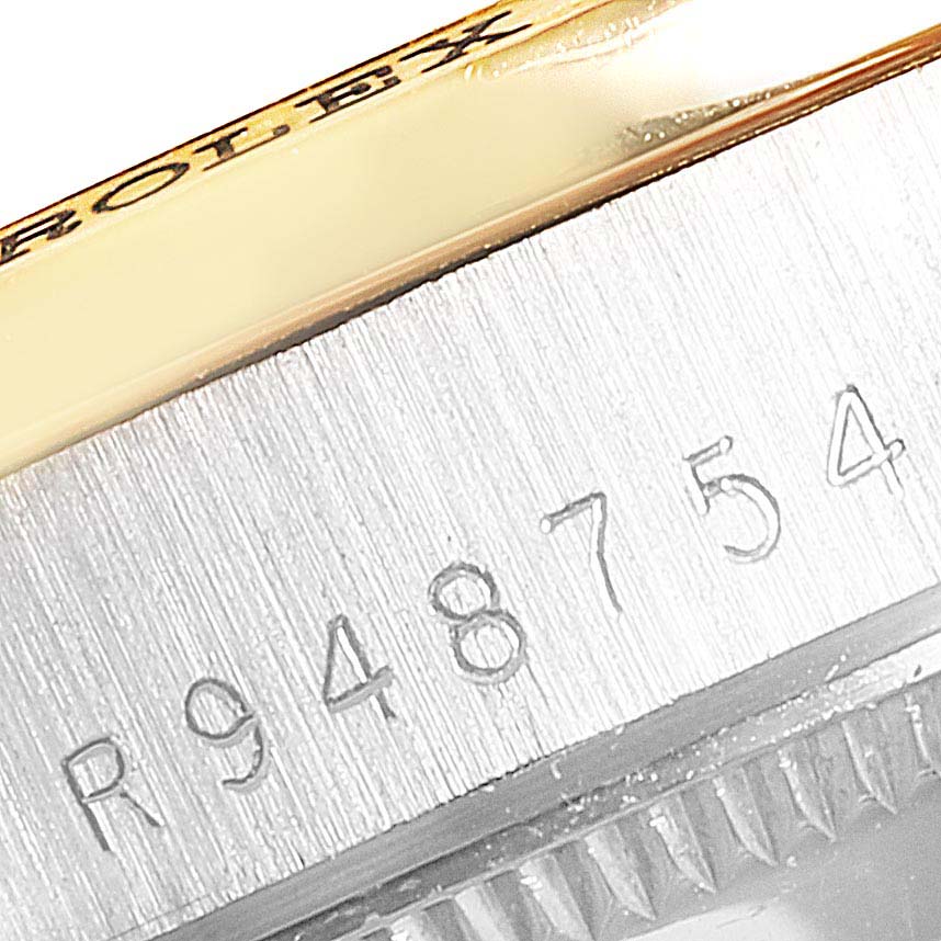 The image shows a close-up of the side of a Rolex President 68149 Women's Yellow Gold Brown Dial 68149 Women's Yellow Gold Brown Dial watch, featuring the engraved serial number.
