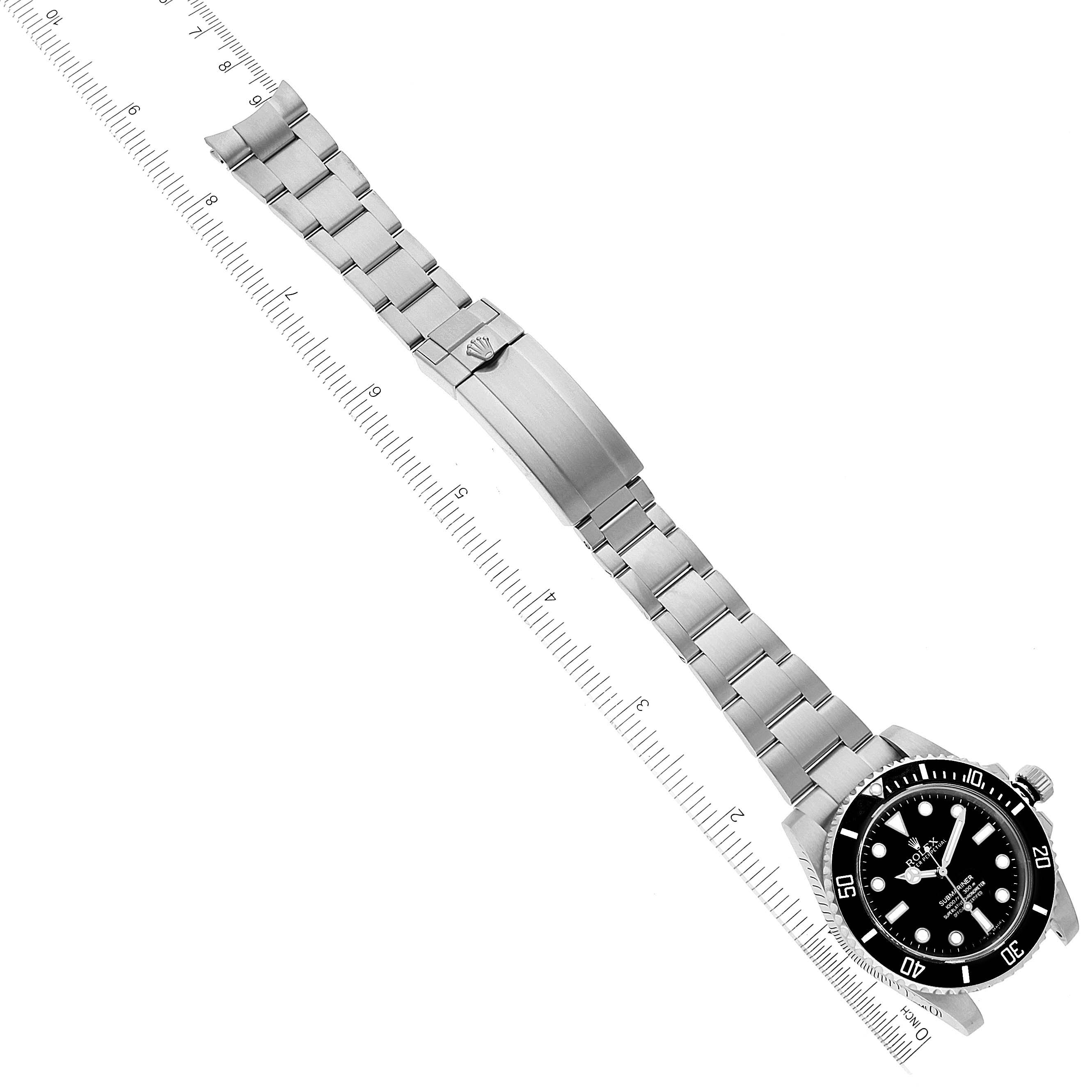 The image shows a top view of a Rolex Submariner 114060 Men's Stainless Steel Black Dial 114060 Men's Stainless Steel Black Dial watch, displaying its face, stainless steel strap, and clasp, aligned beside a ruler.