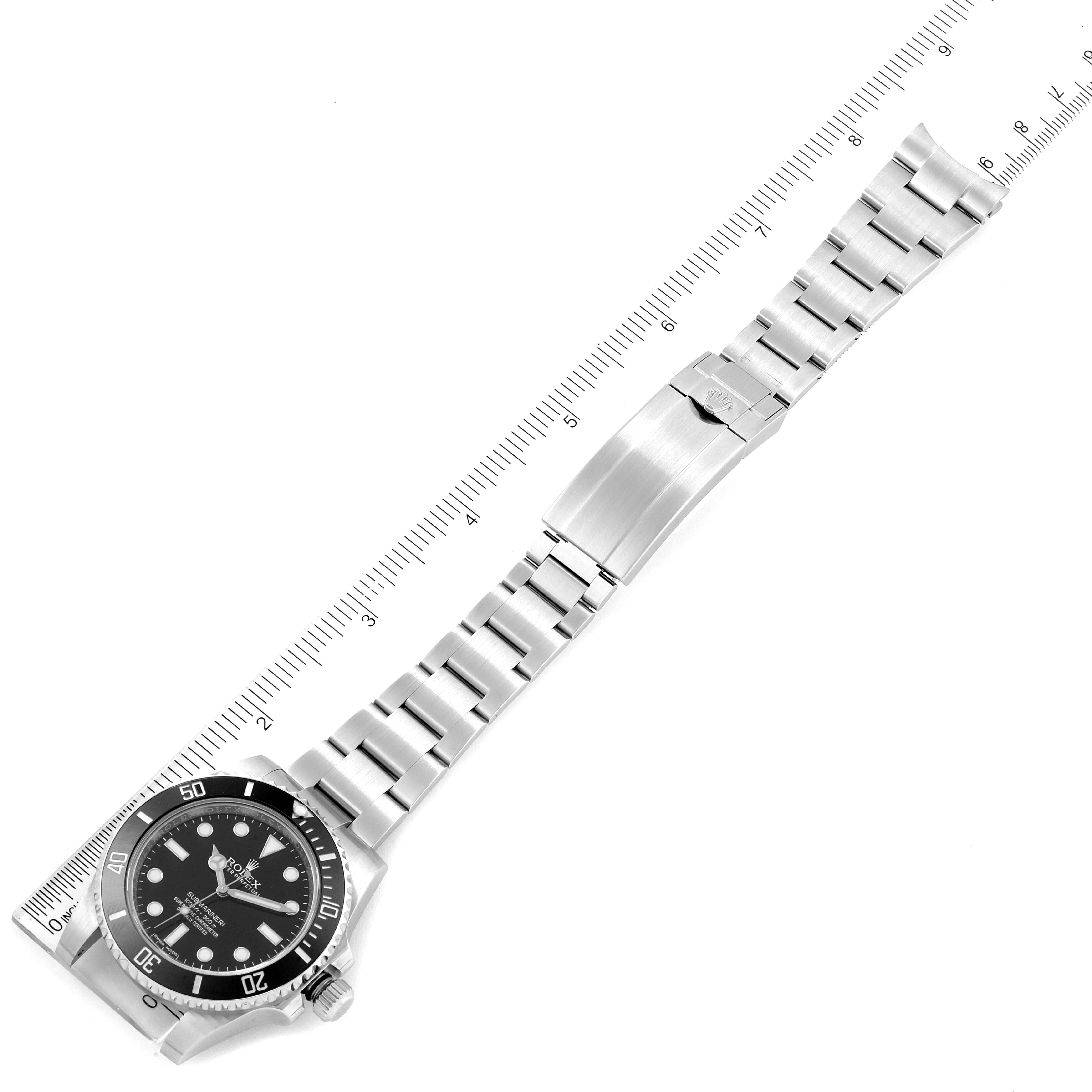 The image shows a top-down view of a Rolex Submariner 114060 Men's Stainless Steel Black Dial 114060 Men's Stainless Steel Black Dial watch with a stainless steel band and a ruler for scale.