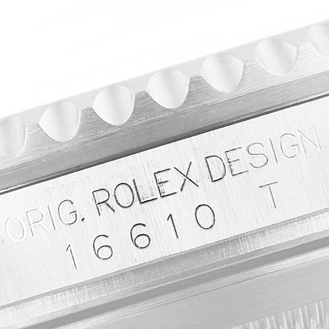 This image shows a close-up of the side of a Rolex Submariner 16610 Men
s Stainless Steel Black Dial 16610 Men
s Stainless Steel Black Dial, highlighting the "ORIG. ROLEX DESIGN" engraving and model number 16610.