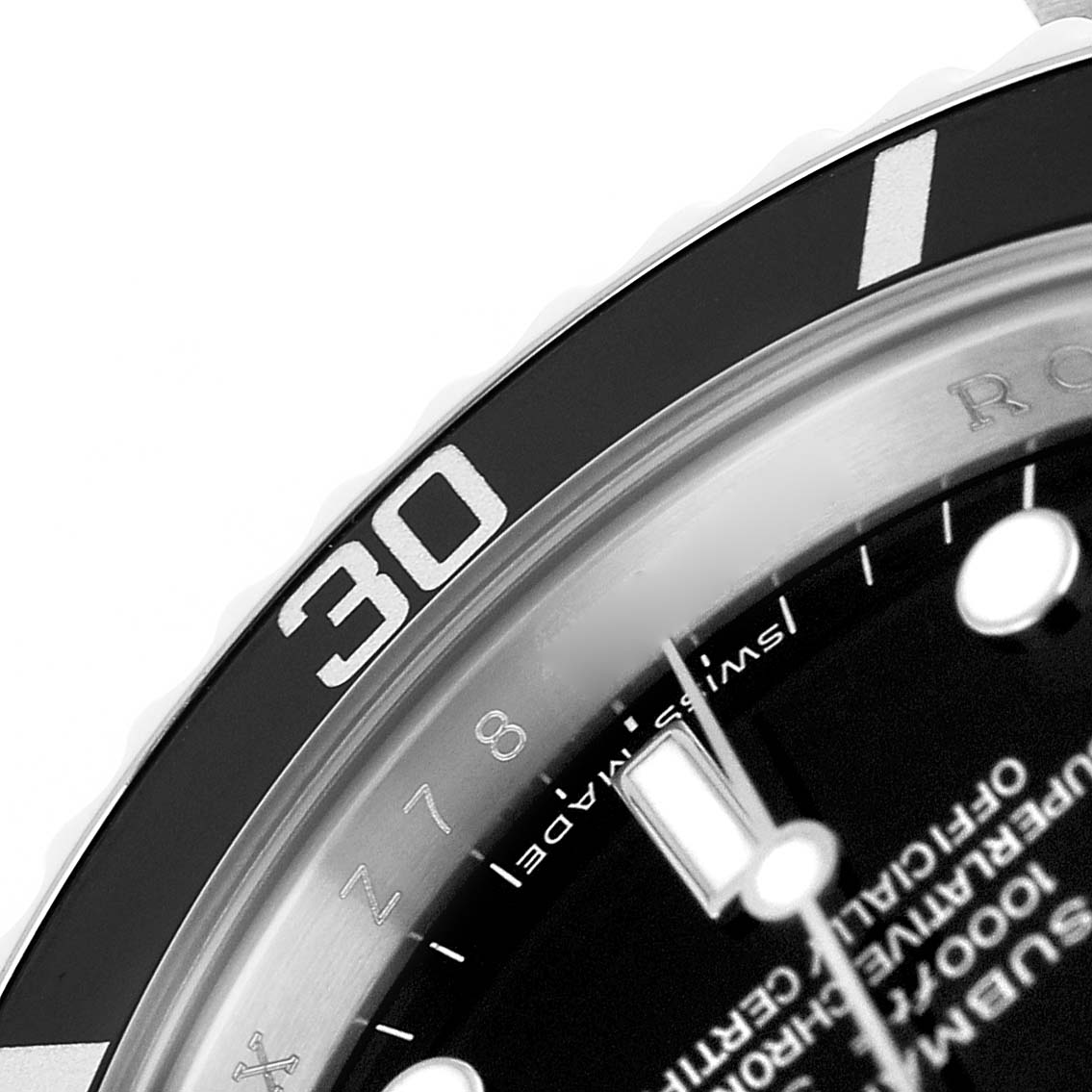 This close-up of the Rolex Submariner 14060M Mens Stainless Steel Black Dial shows the bezel, part of the dial, and indices from a diagonal angle.