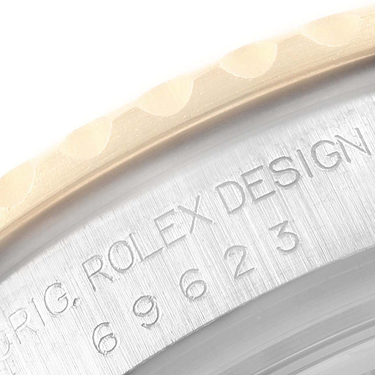 A close-up of the Rolex Yacht-Master 69623 Women's Steel and Gold (two tone) White Dial 69623 Women's Steel and Gold (two tone) White Dial watch shows its bezel and engraved "Rolex Design" text on the case.
