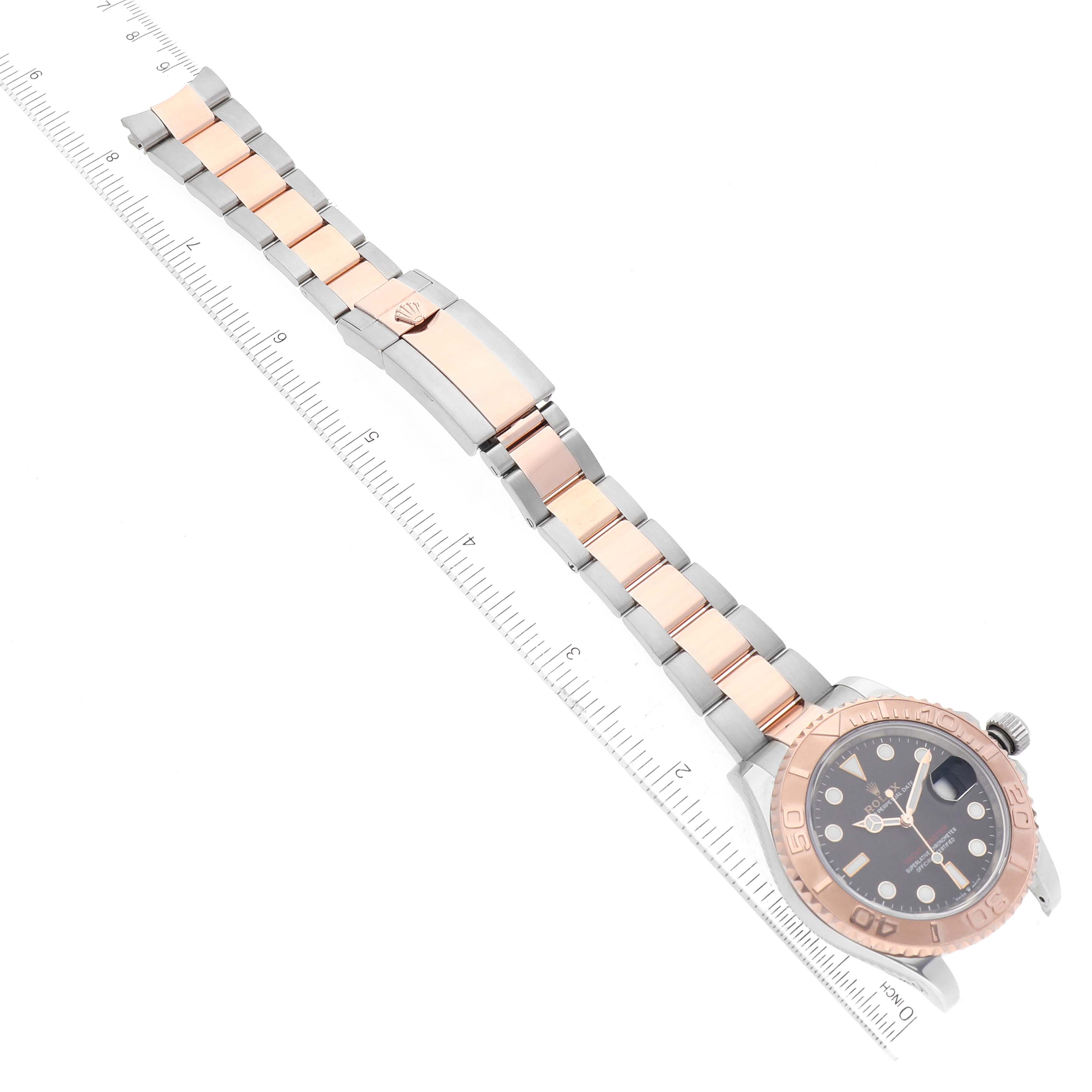 The image shows a Rolex Yacht-Master 126621 Men
s Steel and Gold (two tone) Black Dial 126621 Men
s Steel and Gold (two tone) Black Dial watch laid flat, with its band extended alongside a ruler for size reference.