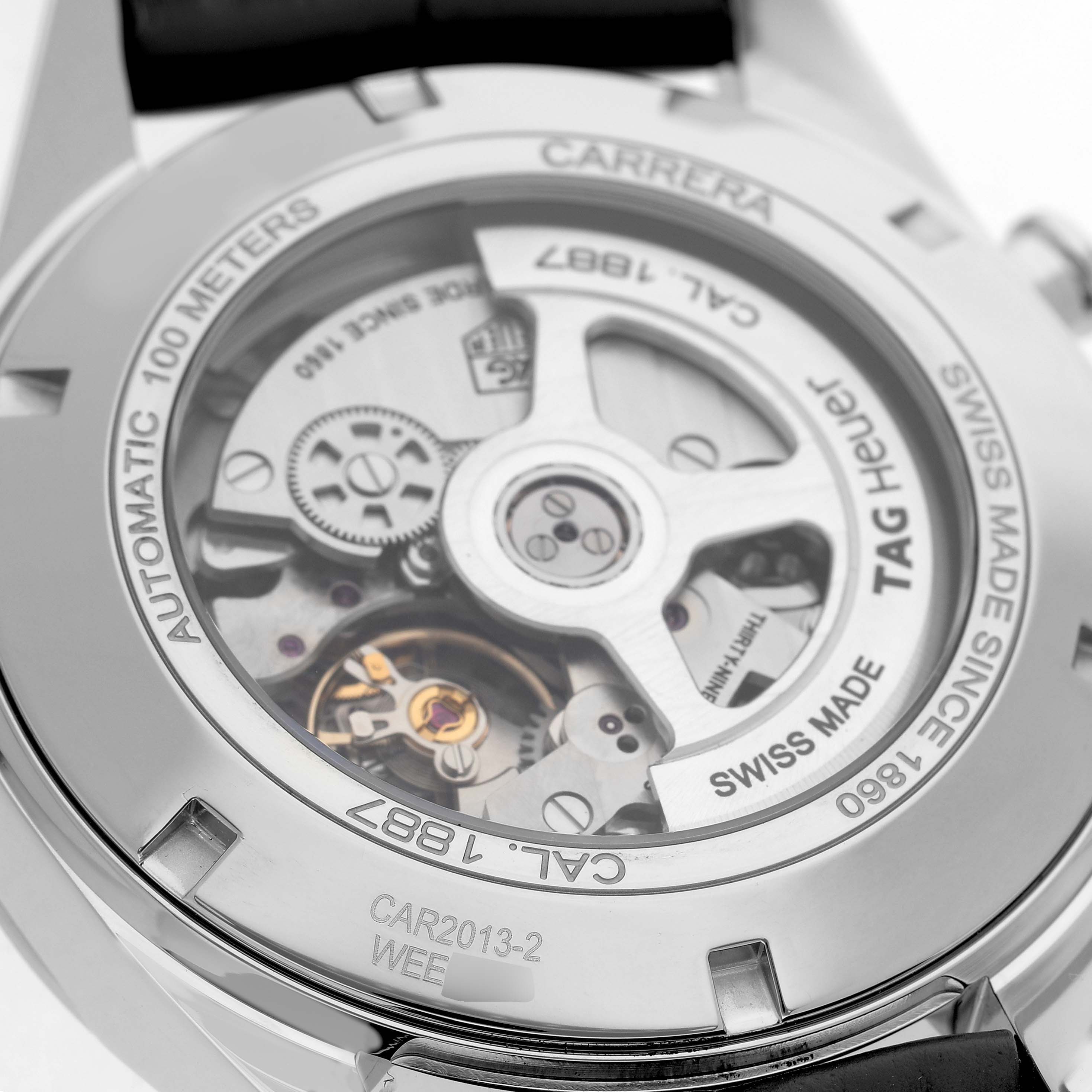 The image shows the back of a Tag Heuer Carrera CAR2013.FC6313 Men's Stainless Steel Grey Dial watch, highlighting the automatic movement and rotor through a clear case back.