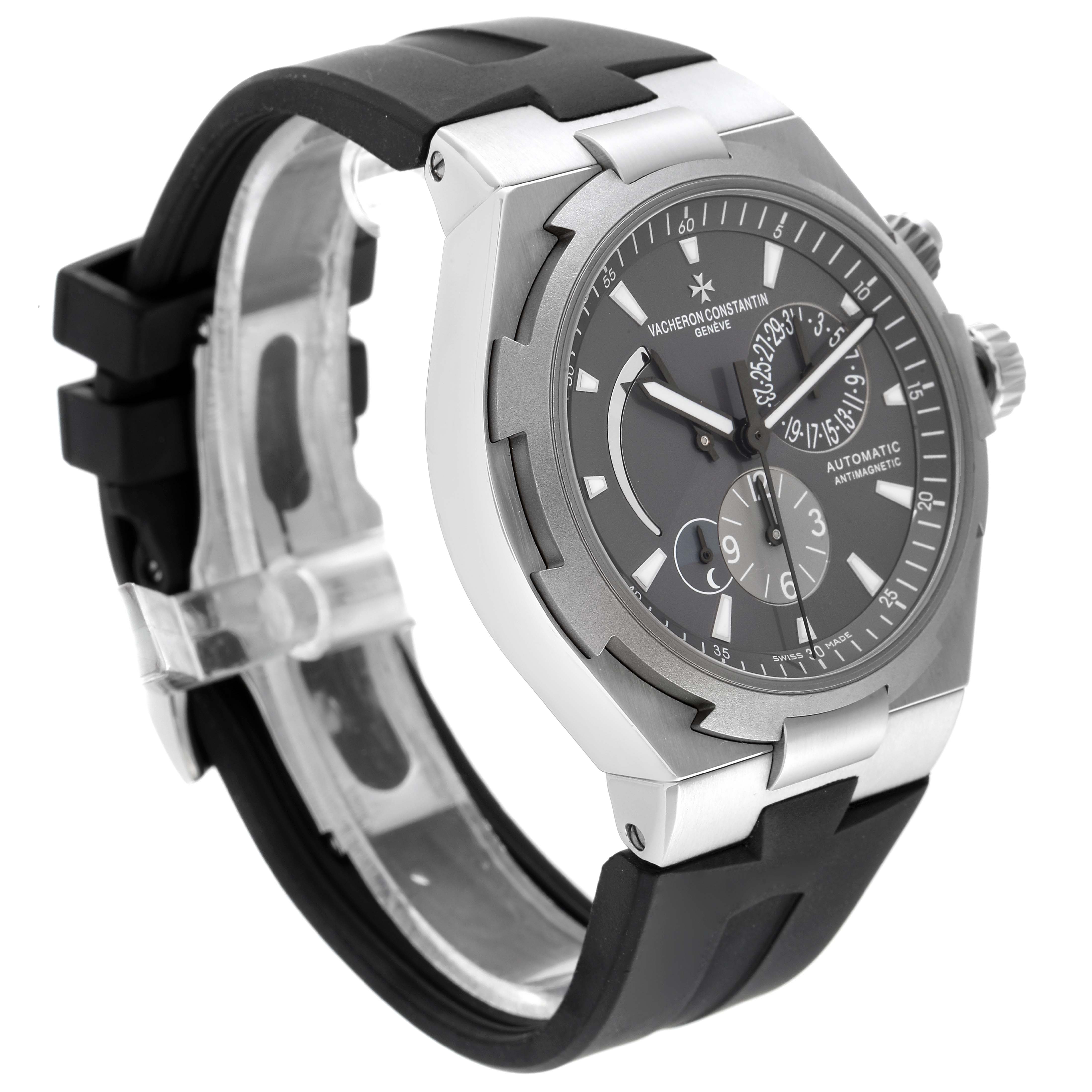 The image shows a three-quarter angle view of the Vacheron Constantin Overseas 47450/000W-9511 Men
s Stainless Steel Black Dial 47450/000W-9511 Men
s Stainless Steel Black Dial watch with a black strap and a grey dial.