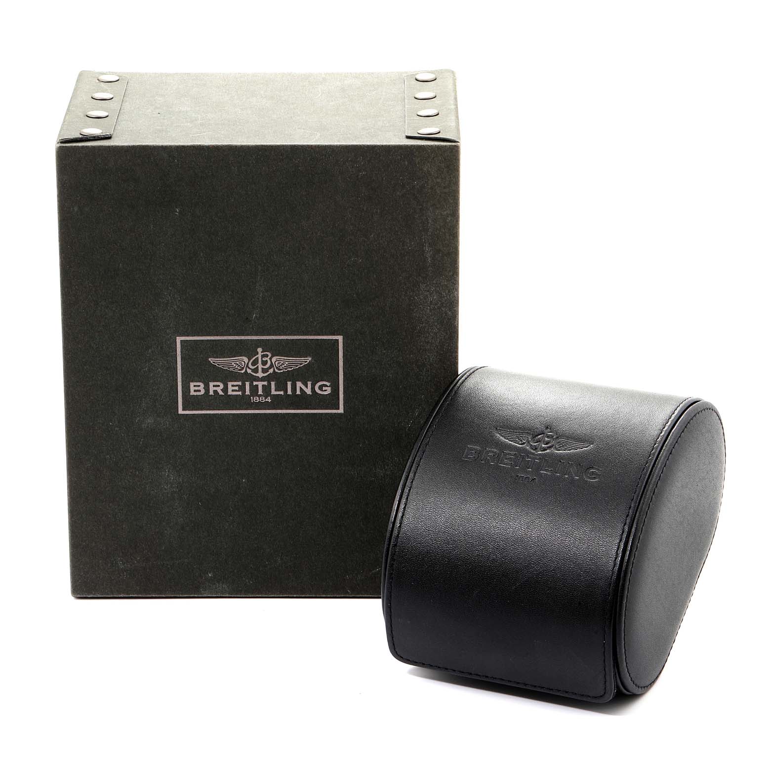 The image shows the packaging of the Chronomat model by Breitling, including a black box and a cylindrical leather watch case.