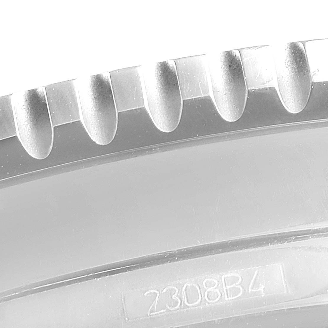 This is a close-up view of the bezel's edge and part of the case back of the Breitling Navitimer A22322 Men's Stainless Steel Black Dial A22322 Men's Stainless Steel Black Dial watch, showing its grooves and a serial number.