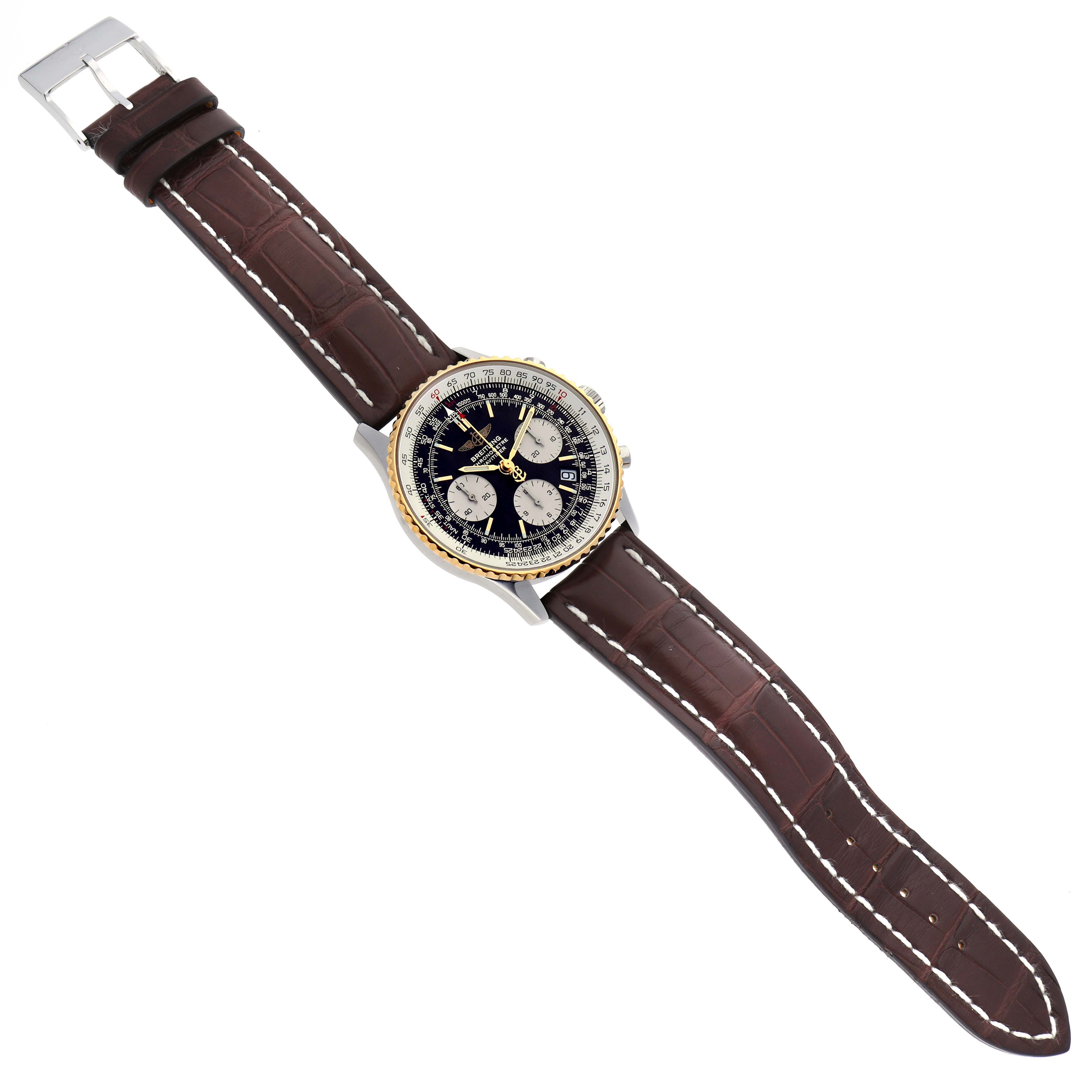 The Breitling Navitimer D23322 Men
s Steel and Gold (two tone) Black Dial D23322 Men
s Steel and Gold (two tone) Black Dial watch is shown from a top-down angle, displaying its face, bezel, and leather strap.