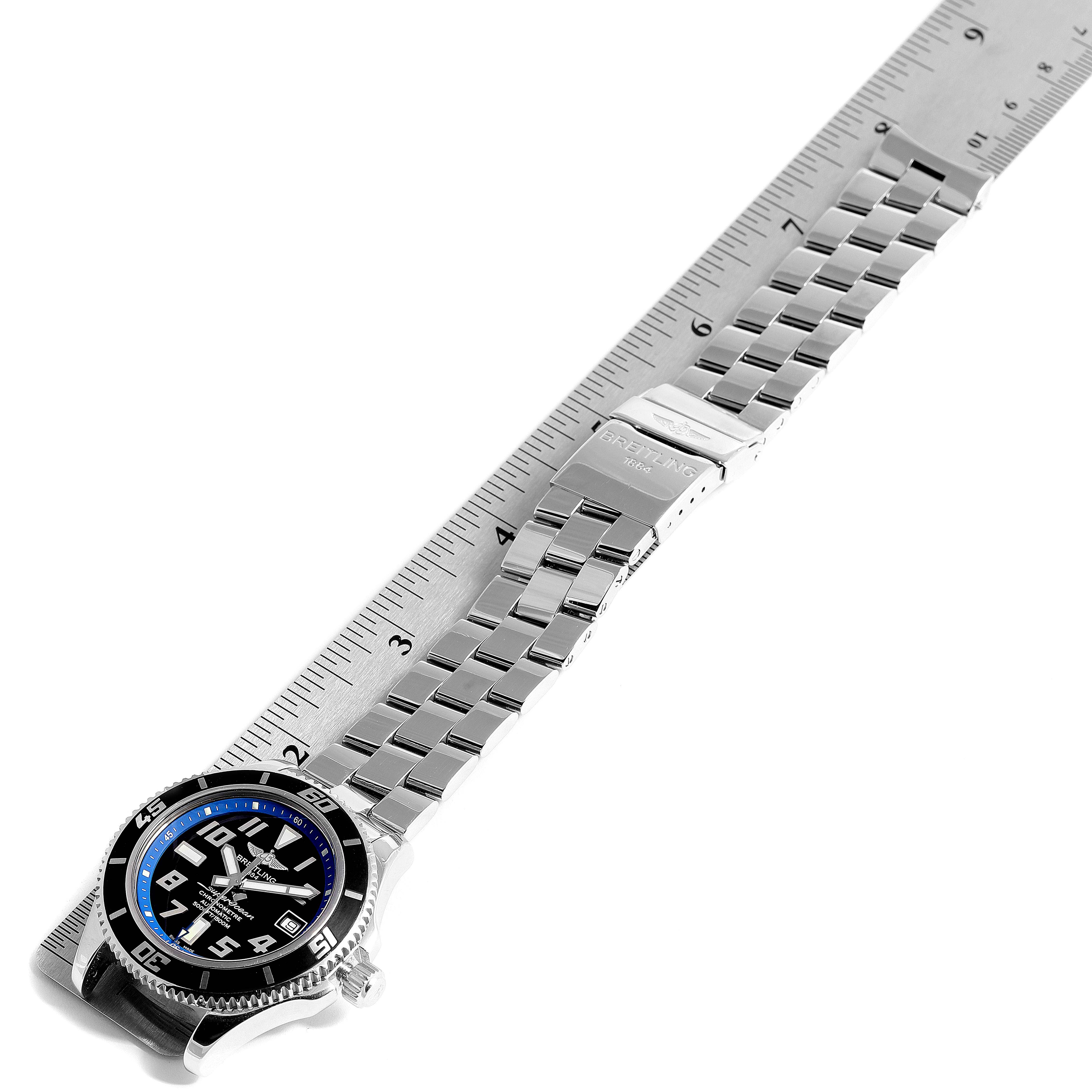 The image shows a Breitling Superocean A17364 Men's Stainless Steel Black Dial A17364 Men's Stainless Steel Black Dial watch laid flat on a ruler, highlighting its bracelet and face from a top-down angle.