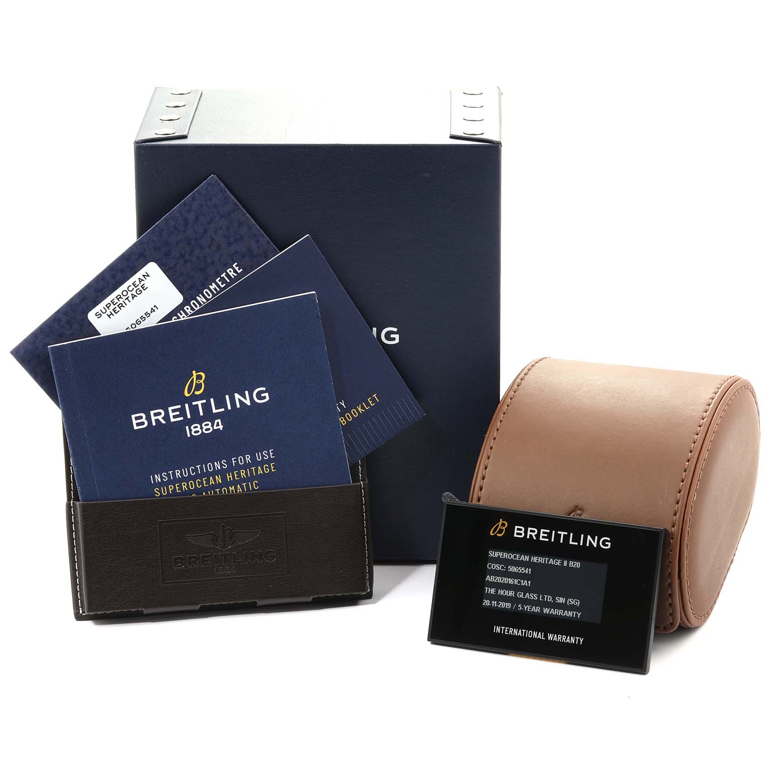 The image shows the packaging, instruction manuals, warranty card, and a leather case for the Superocean model by Breitling.