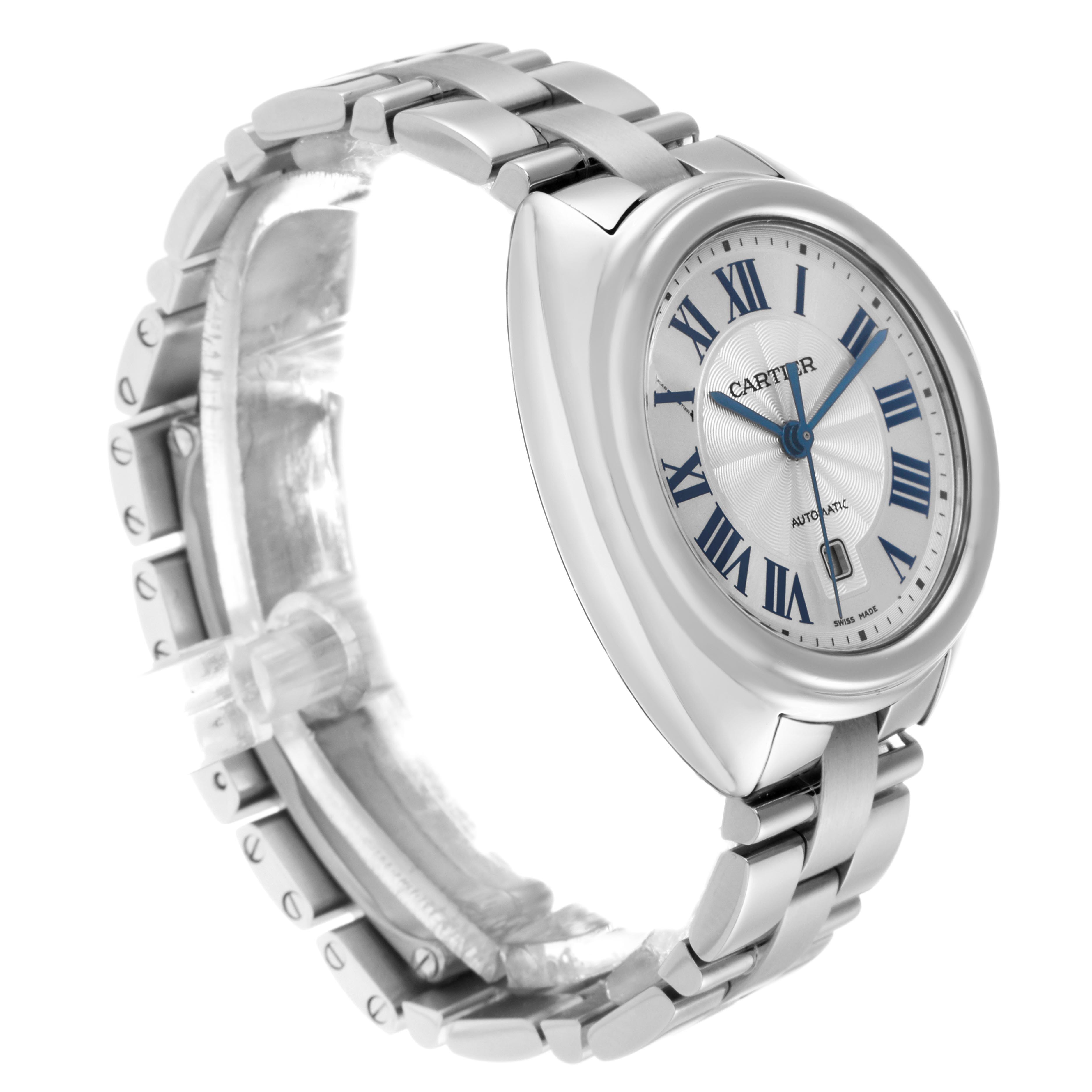 The Cartier Clé watch is shown at a three-quarter angle, highlighting the dial, bezel, and metal bracelet.