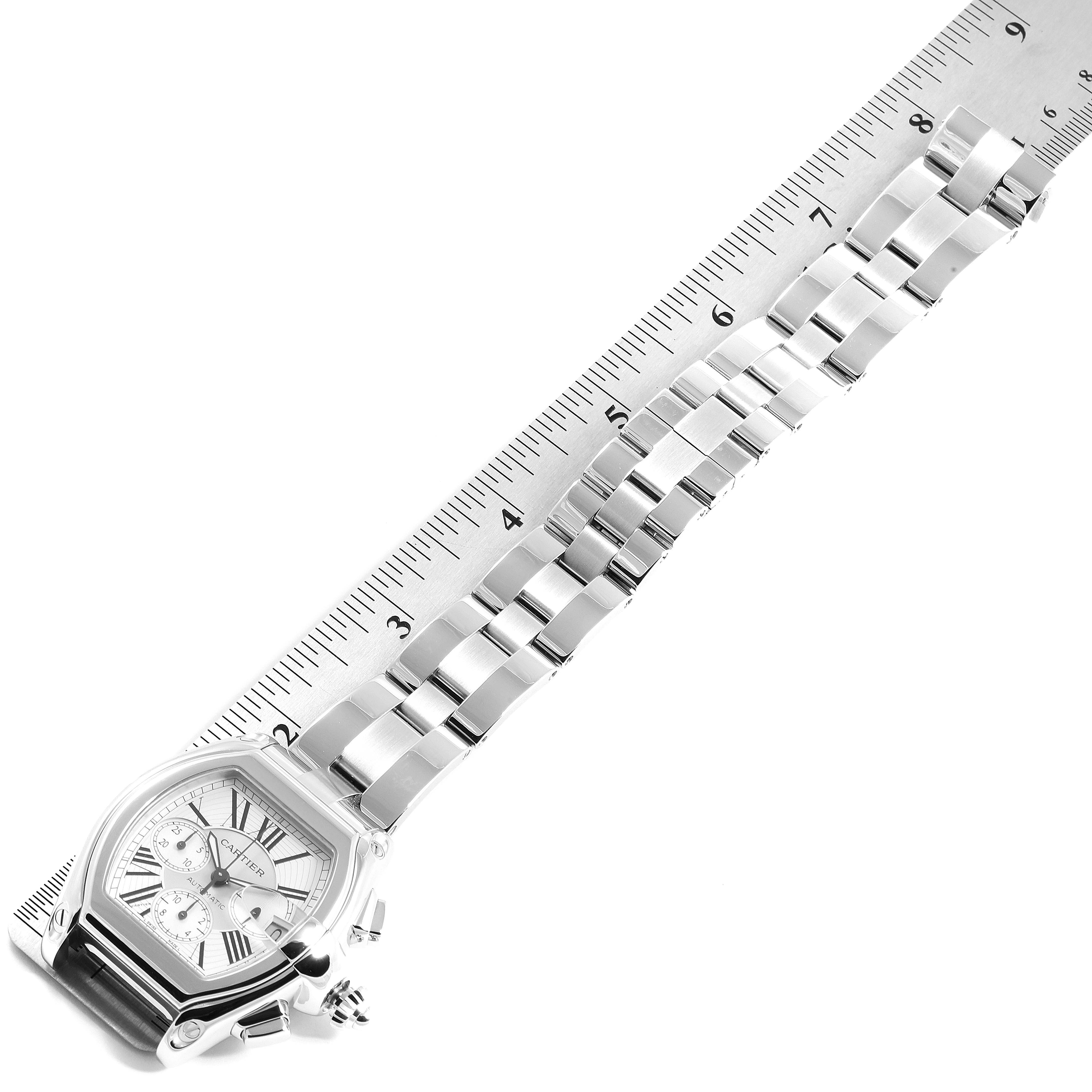 This image shows a Cartier Roadster W62019X6 Men
s Stainless Steel Silver Dial W62019X6 Men
s Stainless Steel Silver Dial watch with its metal band measured against a ruler.