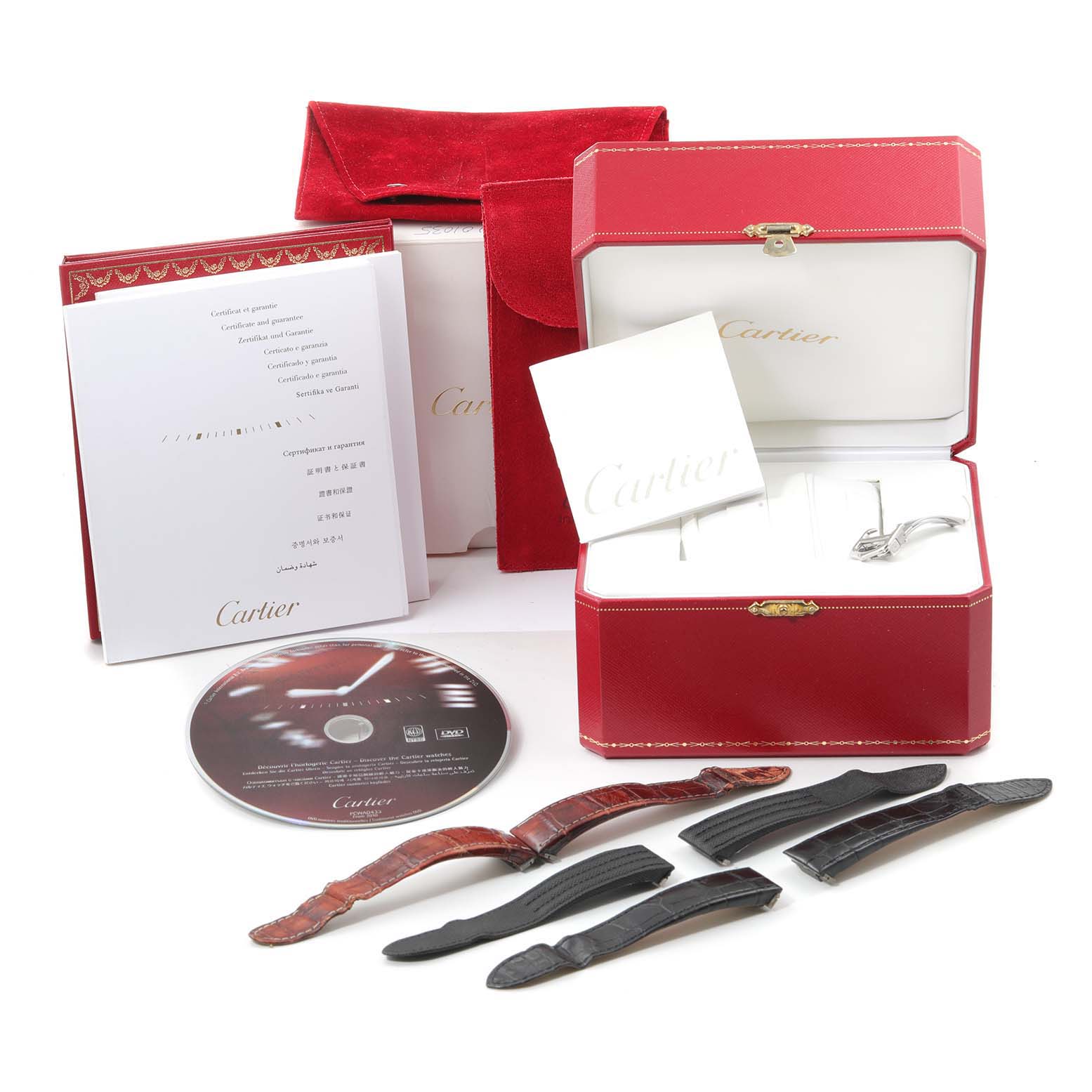 The image shows accessories for the Cartier Roadster W62019X6 Men
s Stainless Steel Silver Dial W62019X6 Men
s Stainless Steel Silver Dial model, including a box, booklets, a DVD, and various straps.