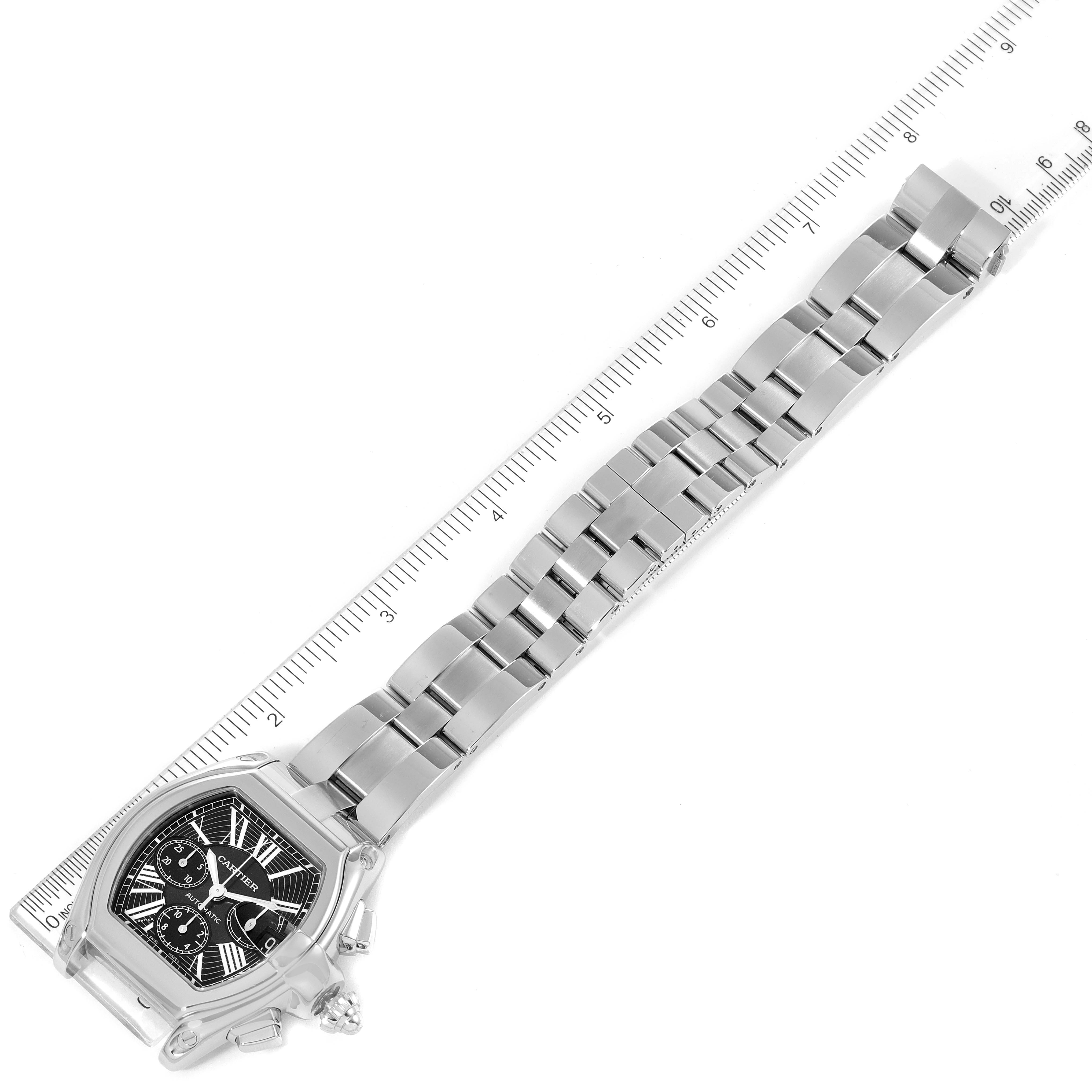 The Cartier Roadster W62020X6 Men
s Stainless Steel Black Dial W62020X6 Men
s Stainless Steel Black Dial watch is shown from a top-down angle, displaying its entire bracelet and face next to a measuring ruler.