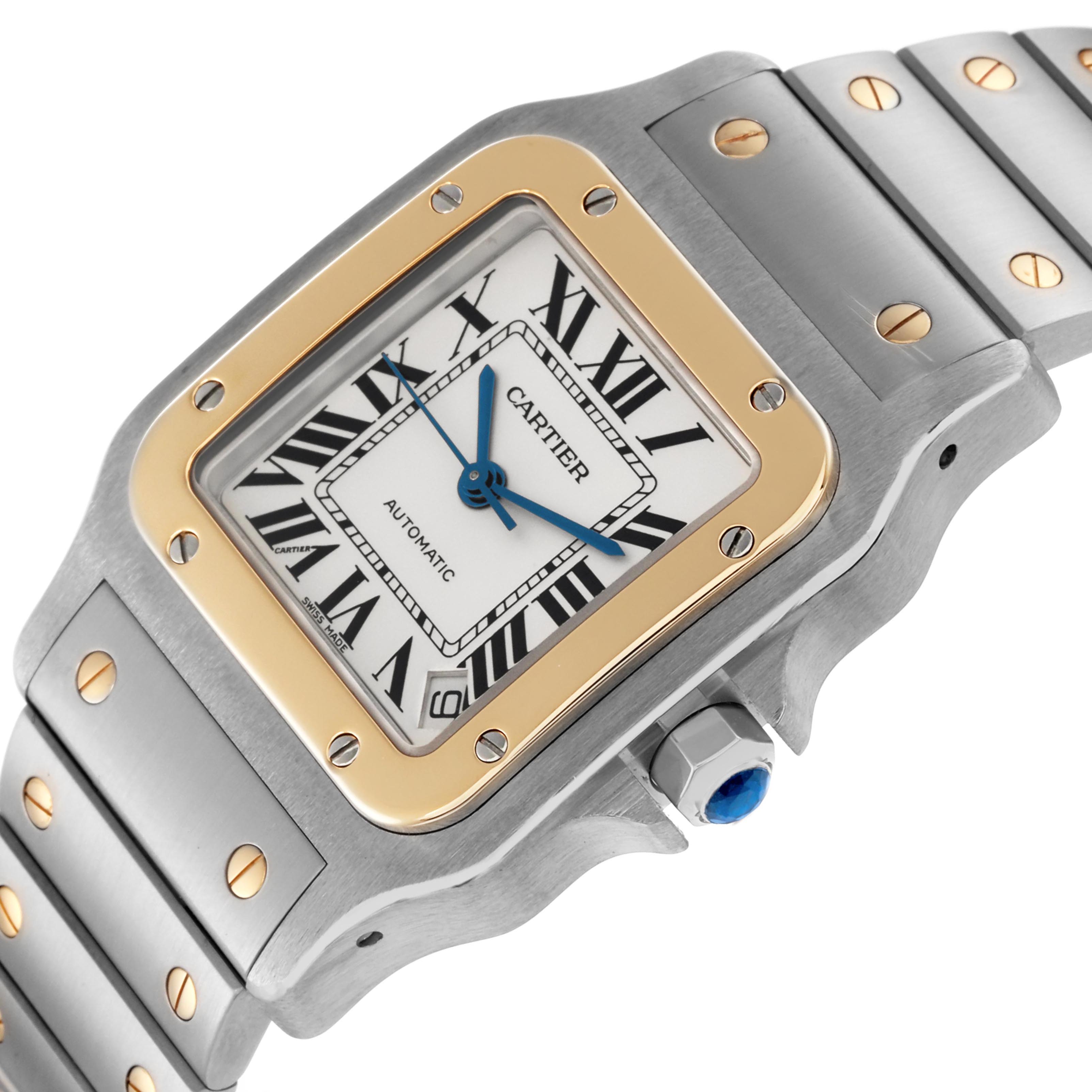 The Cartier Santos W20099C4 Men
s Steel and Gold (two tone) Silver Dial W20099C4 Men
s Steel and Gold (two tone) Silver Dial watch is shown from a top angle, highlighting the face, bezel, bracelet, and crown with a blue cabochon.