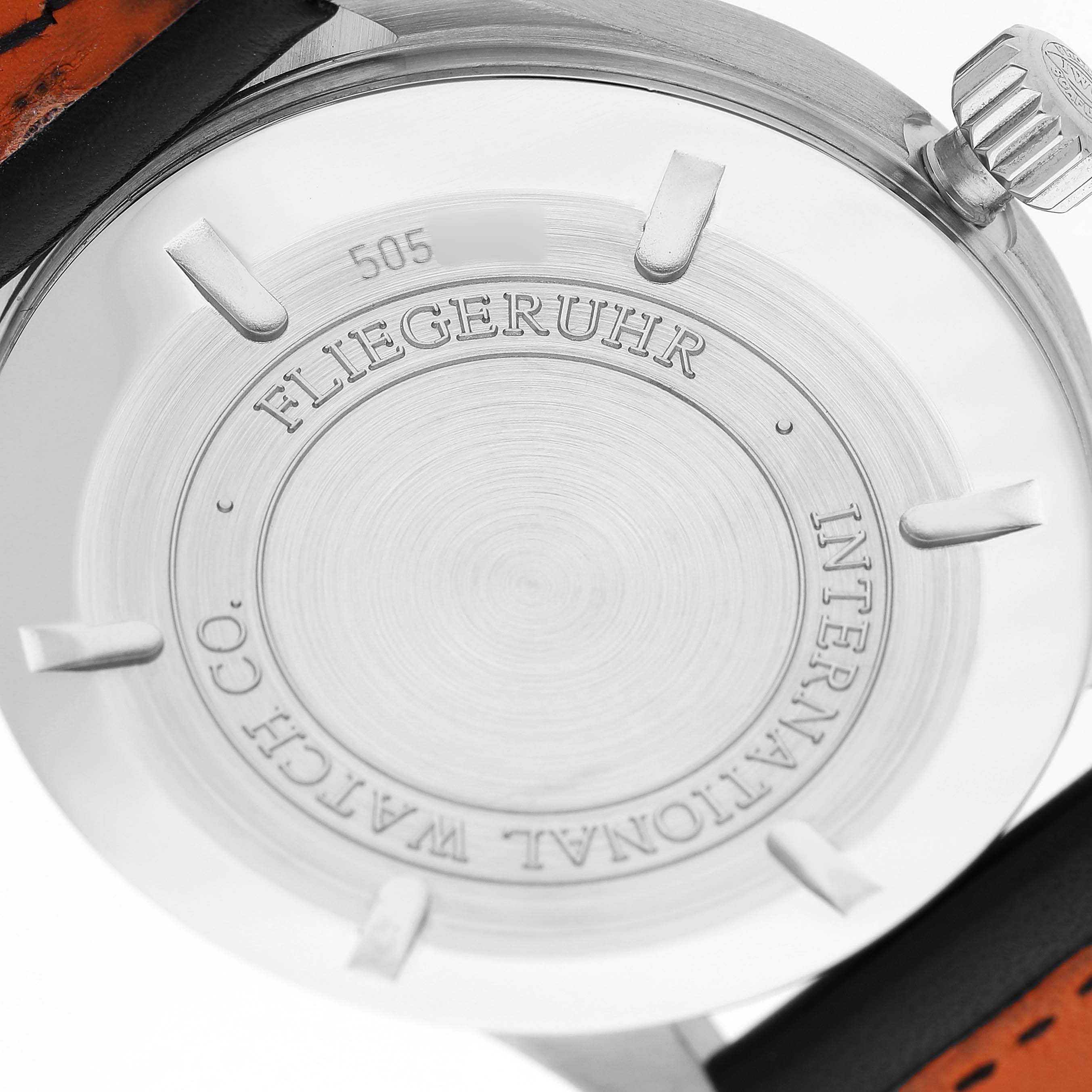 The image shows the back case of an IWC Pilot IW325501 Men's Stainless Steel Black Dial watch, displaying the engraving and crown at an angle.